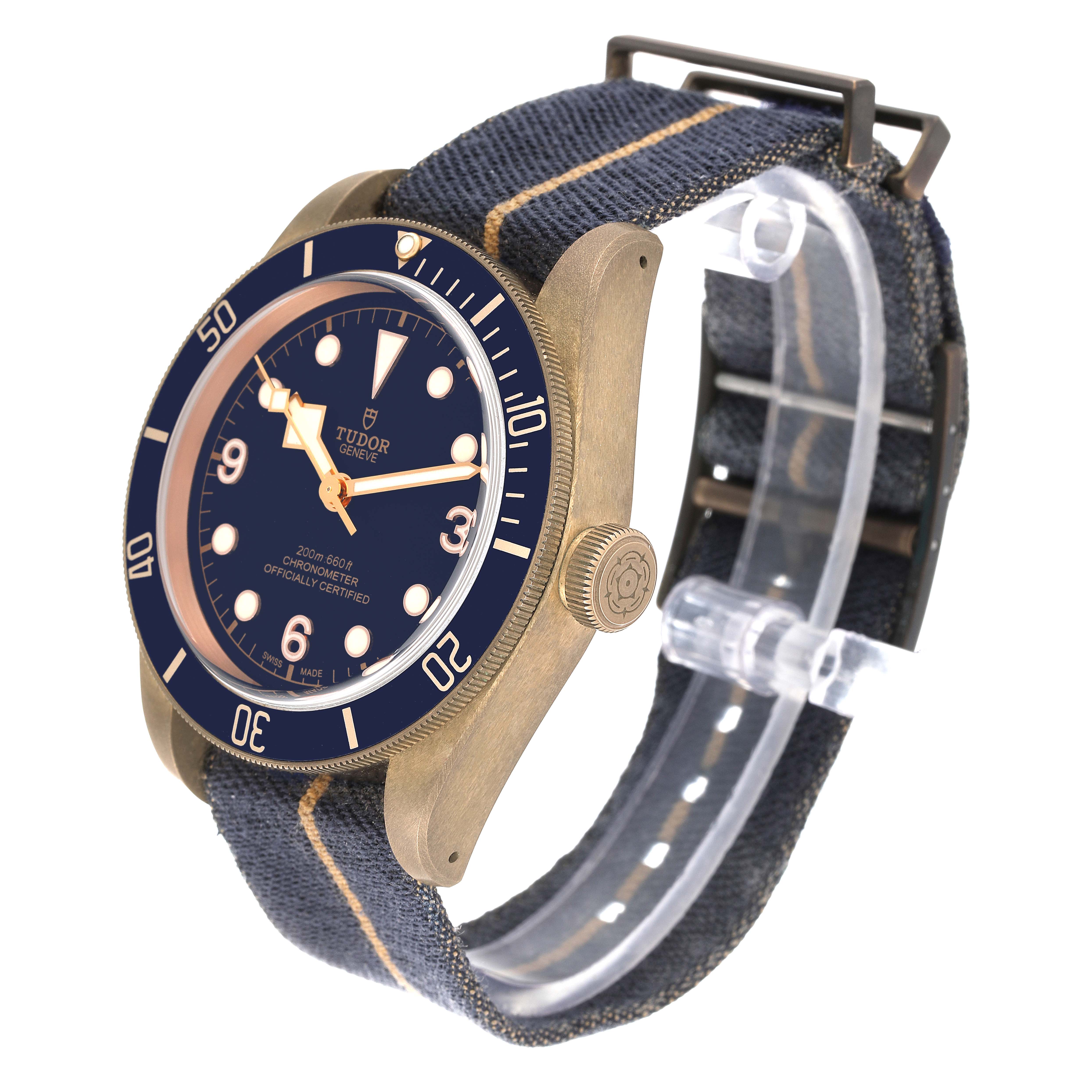 The Tudor Heritage Black Bay 79250BB Men's Ceramic Blue Dial 79250BB Men's Ceramic Blue Dial watch is shown at an angled view, displaying its navy dial, bronze case, and denim-style strap.