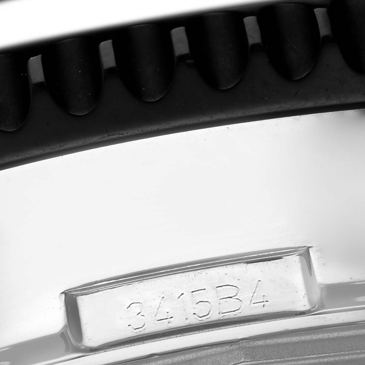 The image shows a close-up of the bezel teeth and a serial number on the Breitling Chronoliner Y2431012/BE10 Men's Stainless Steel Black Dial Y2431012/BE10 Men's Stainless Steel Black Dial watch.