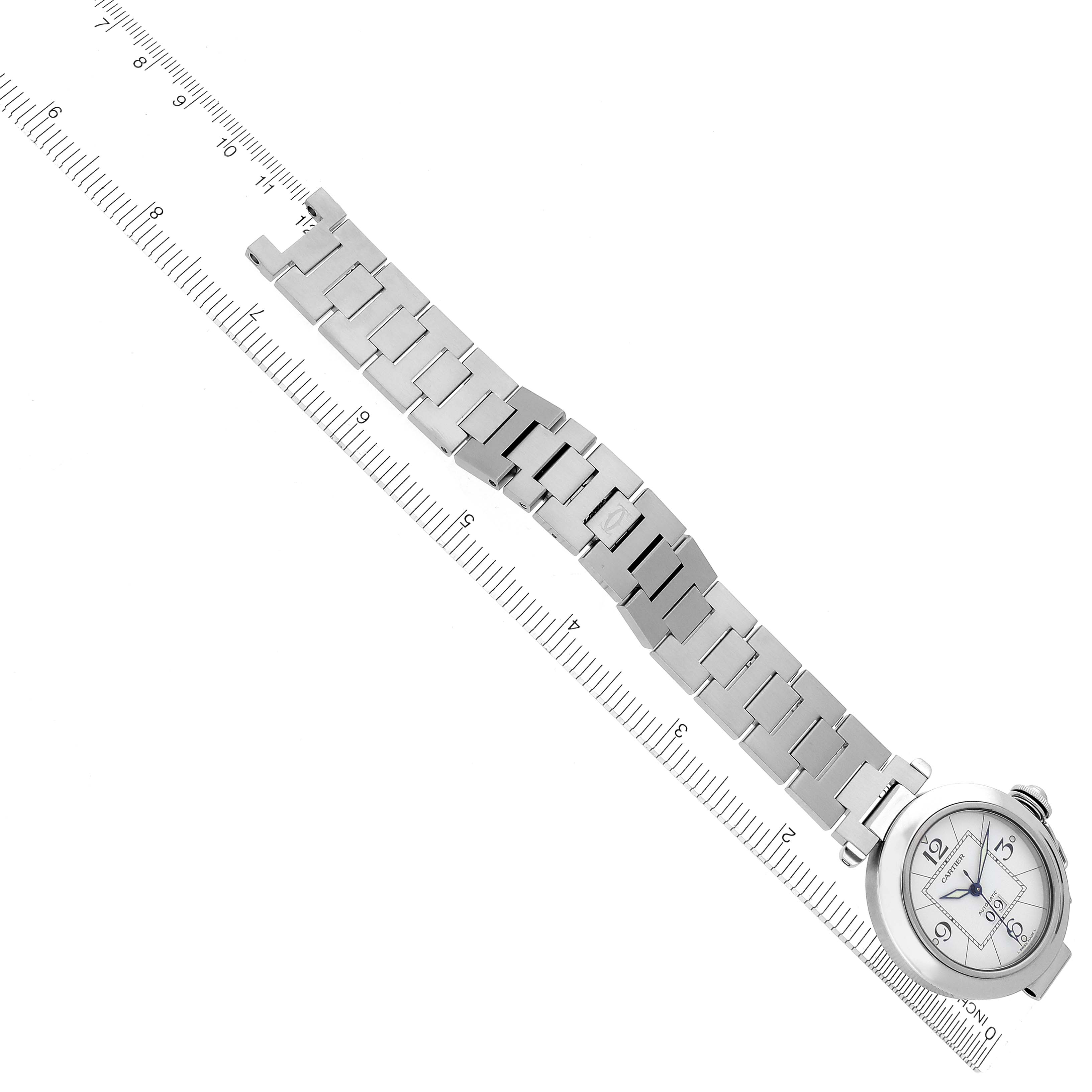 The Cartier Pasha W31055M7 Men's Stainless Steel Silver Dial W31055M7 Men's Stainless Steel Silver Dial watch is shown at an angle with its face and full metal bracelet visible, aligned next to a measuring ruler.
