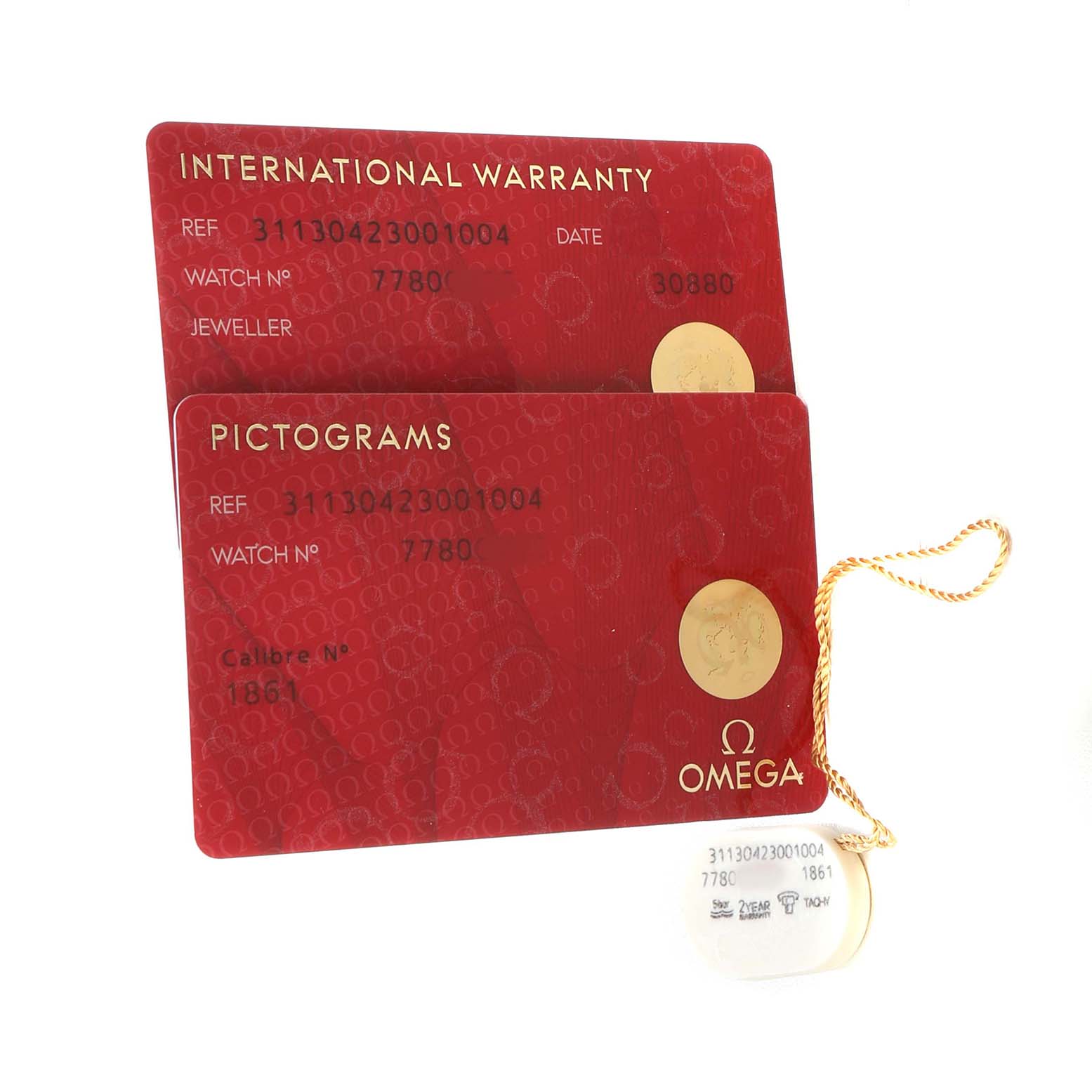 The image shows the warranty and pictogram cards for the Omega Speedmaster 311.30.42.30.01.004 Men's Stainless Steel Black Dial, along with an attached tag.