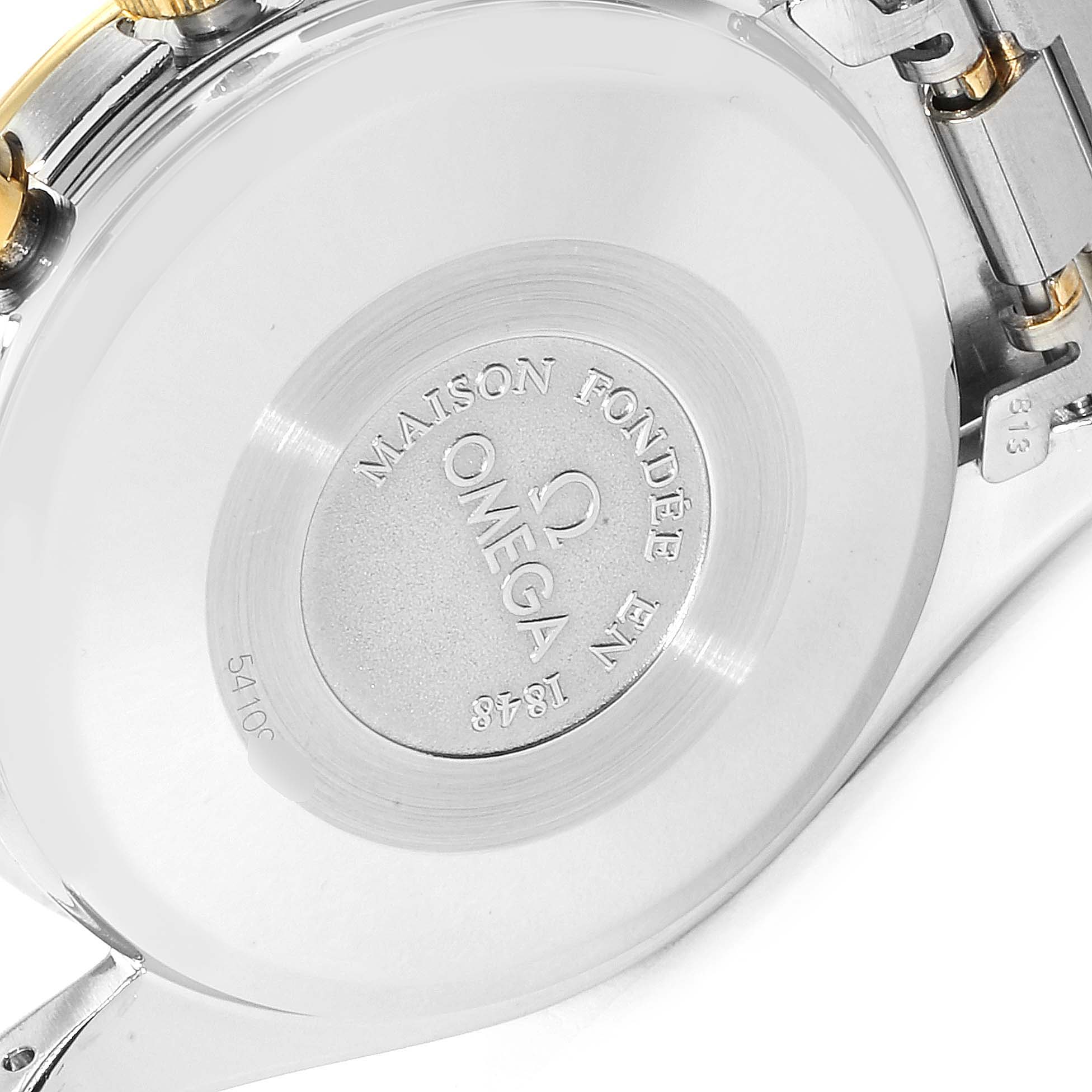 This image shows the back case of an Omega Speedmaster 3330.20.00 Men's Steel and Gold (two tone) White Dial 3330.20.00 Men's Steel and Gold (two tone) White Dial watch, highlighting the engraved logo and text.