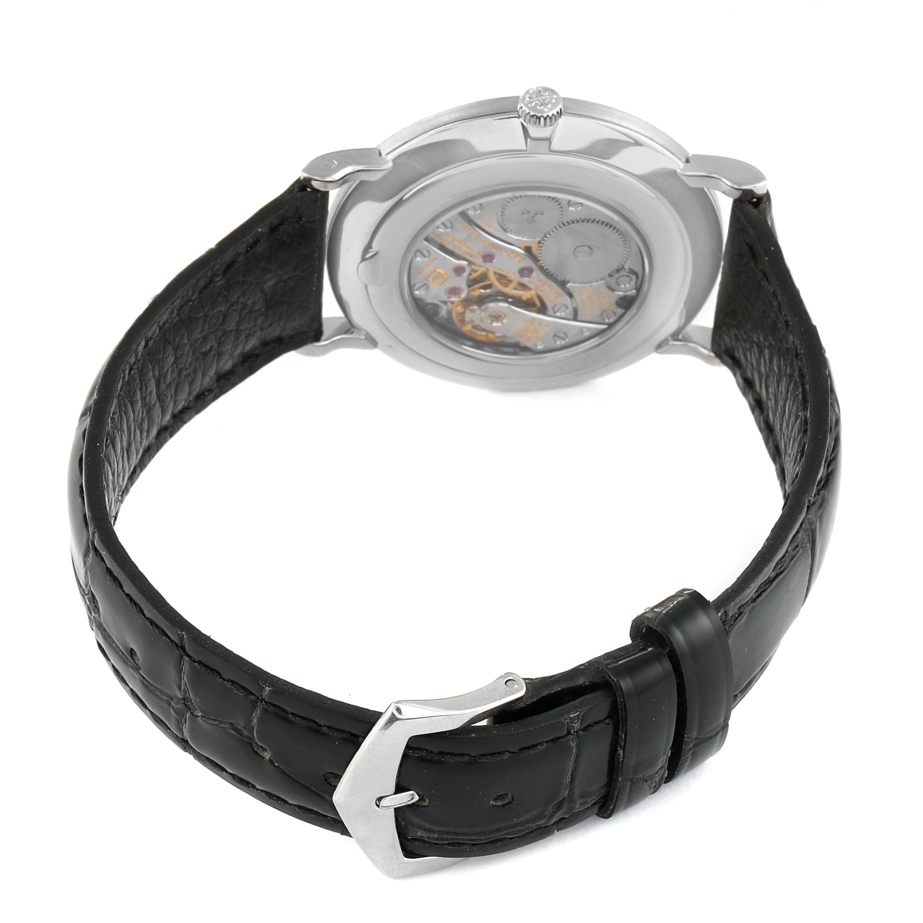 The image shows the back view of a Patek Philippe Calatrava 5119G Men
s White Gold White Dial 5119G Men
s White Gold White Dial watch, highlighting its transparent case back and black leather strap.