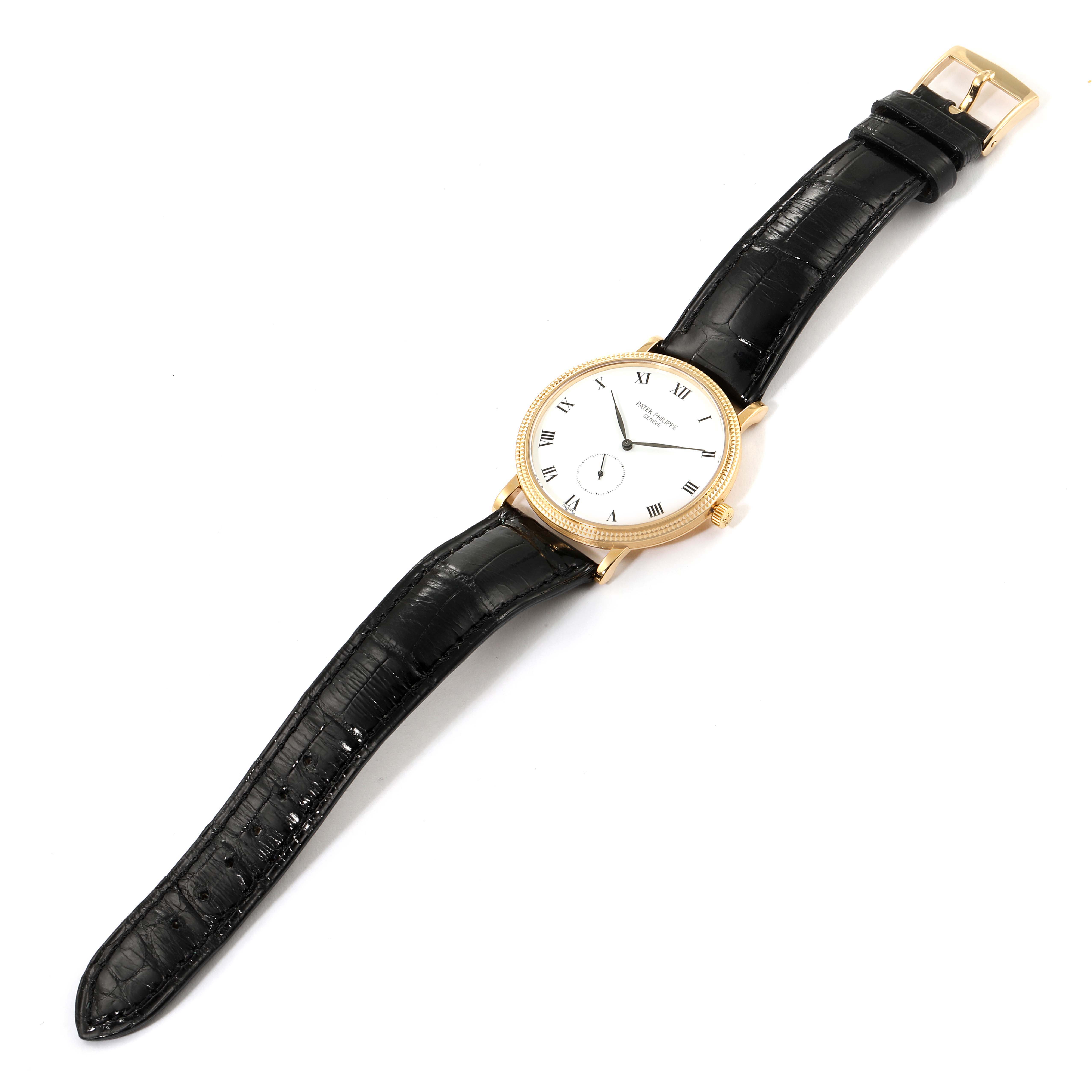 The image shows a Patek Philippe Calatrava 3919 Men's Yellow Gold White Dial 3919 Men's Yellow Gold White Dial watch at an angle displaying its face, gold case, and black leather strap.