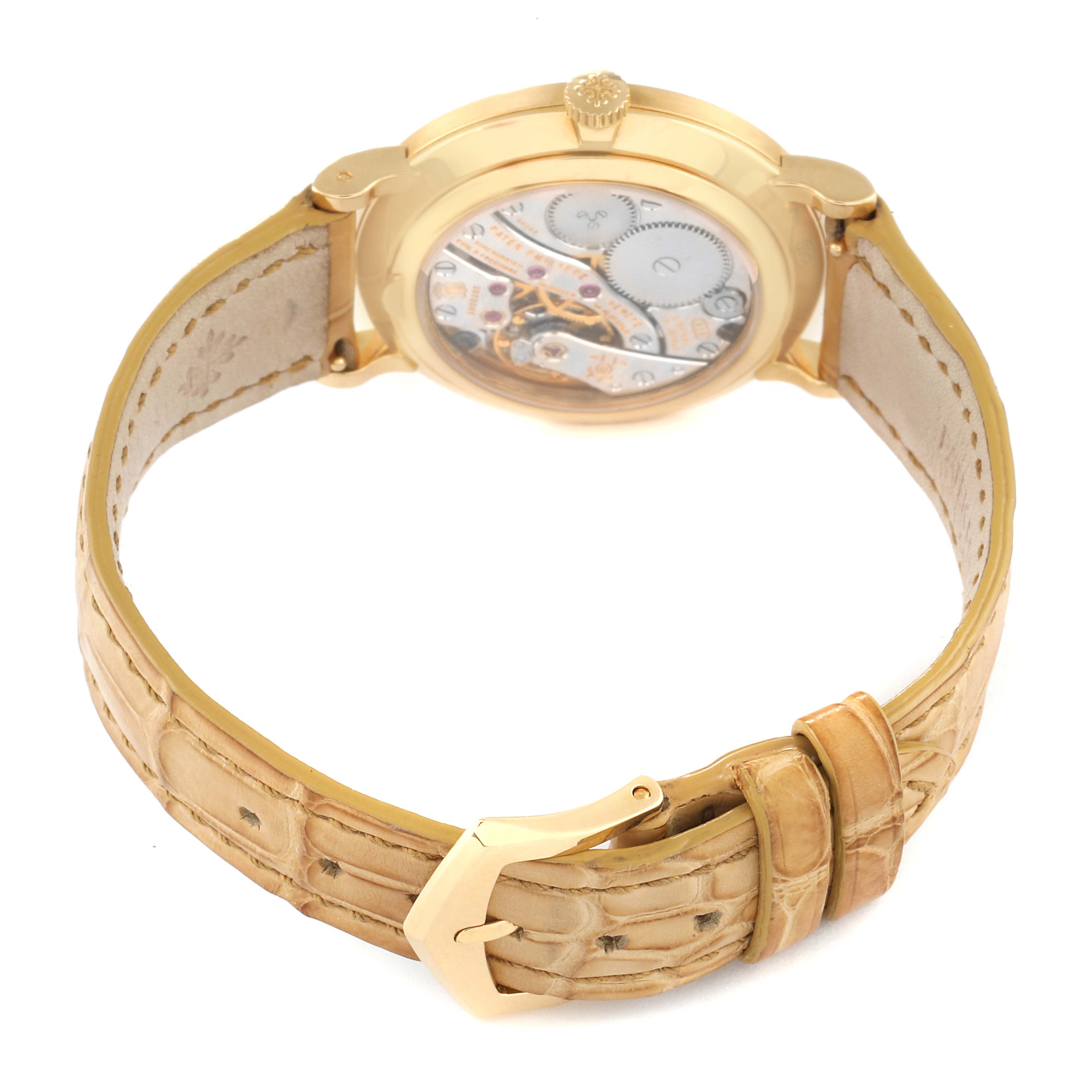 The image shows the Patek Philippe Calatrava 7119J Women's Yellow Gold White Dial 7119J Women's Yellow Gold White Dial model from the back, displaying the movement and leather strap with a buckle.