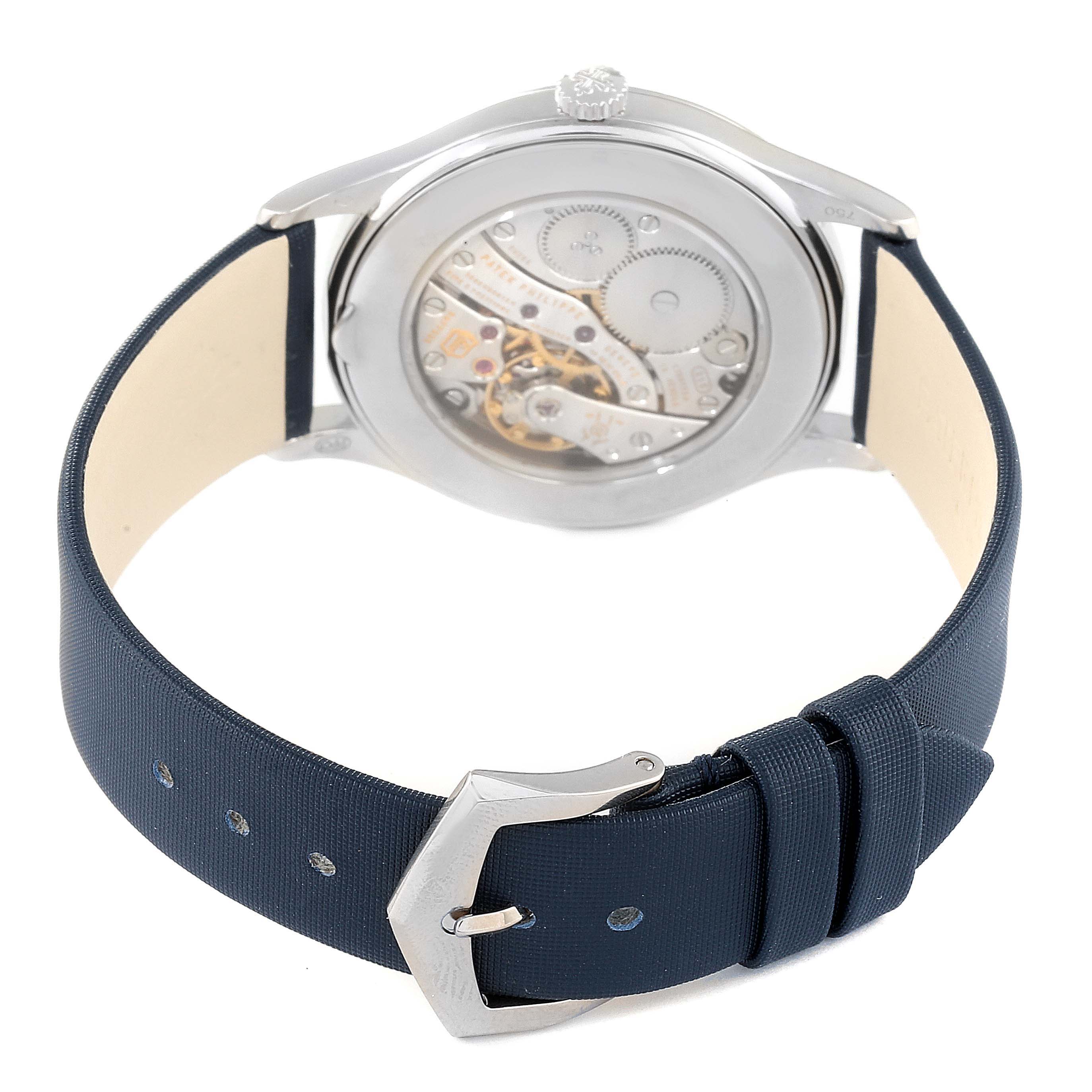 The image shows the back view of a Patek Philippe Calatrava 4897G-001 Women's White Gold Blue Dial 4897G-001 Women's White Gold Blue Dial watch, highlighting its movement and the navy blue strap with a buckle.