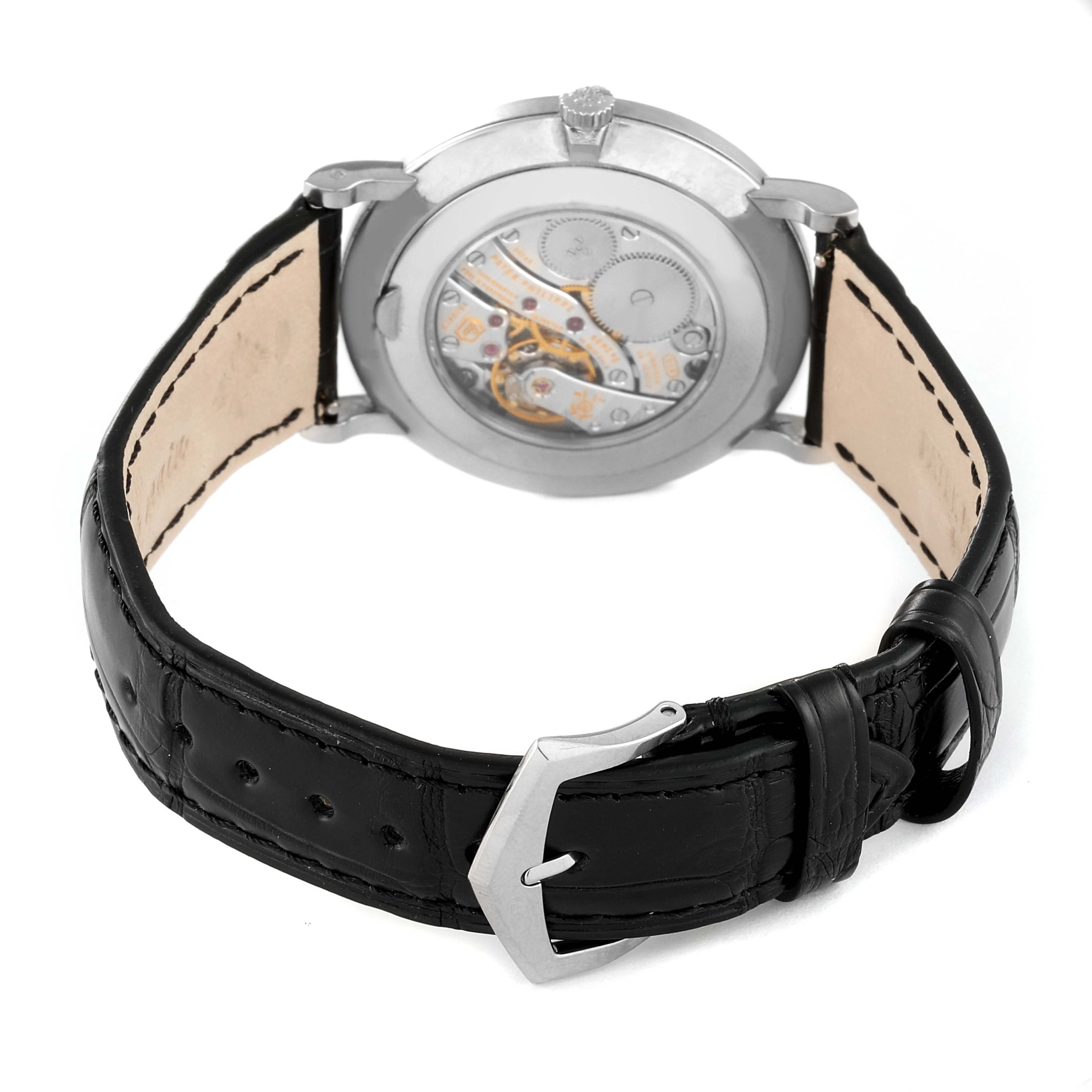 The image shows the back view of a Patek Philippe Calatrava 5116G Men
s White Gold White Dial 5116G Men
s White Gold White Dial watch, highlighting its movement and black leather strap.