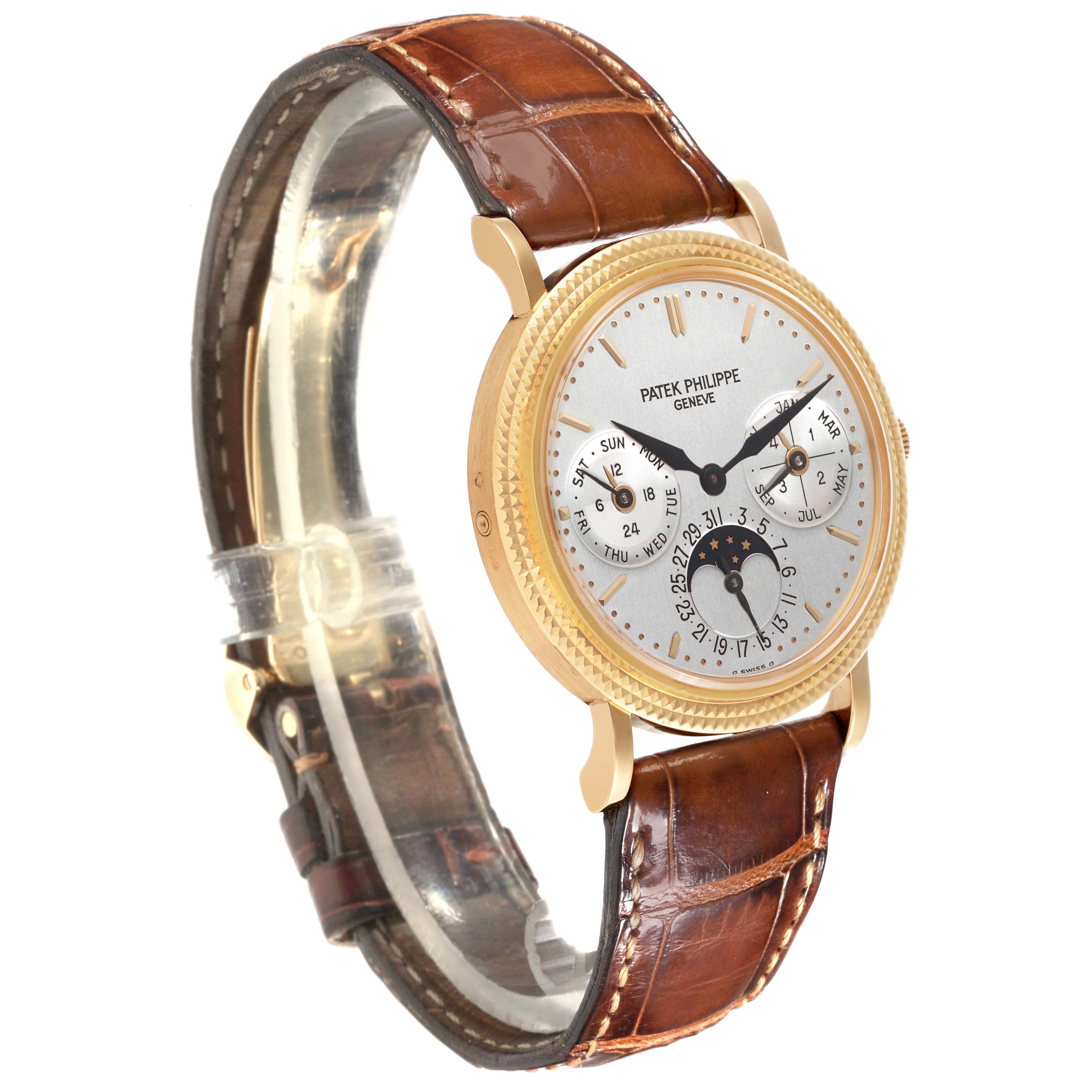 The Patek Philippe Complications 5039J-001 Men's Yellow Gold Silver Dial 5039J-001 Men's Yellow Gold Silver Dial watch is shown at a three-quarter angle, highlighting the dial, bezel, and brown leather strap.