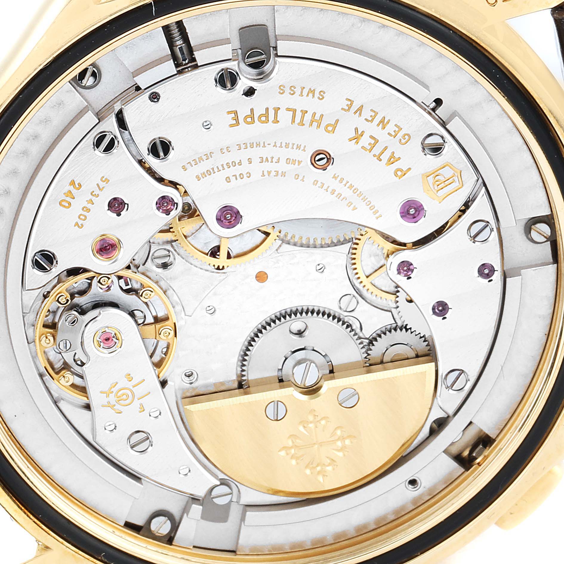 The image shows the movement mechanism of a Patek Philippe Complications 5130J Men's Yellow Gold Silver Dial 5130J Men's Yellow Gold Silver Dial watch from the back, revealing gears and intricate detailing.