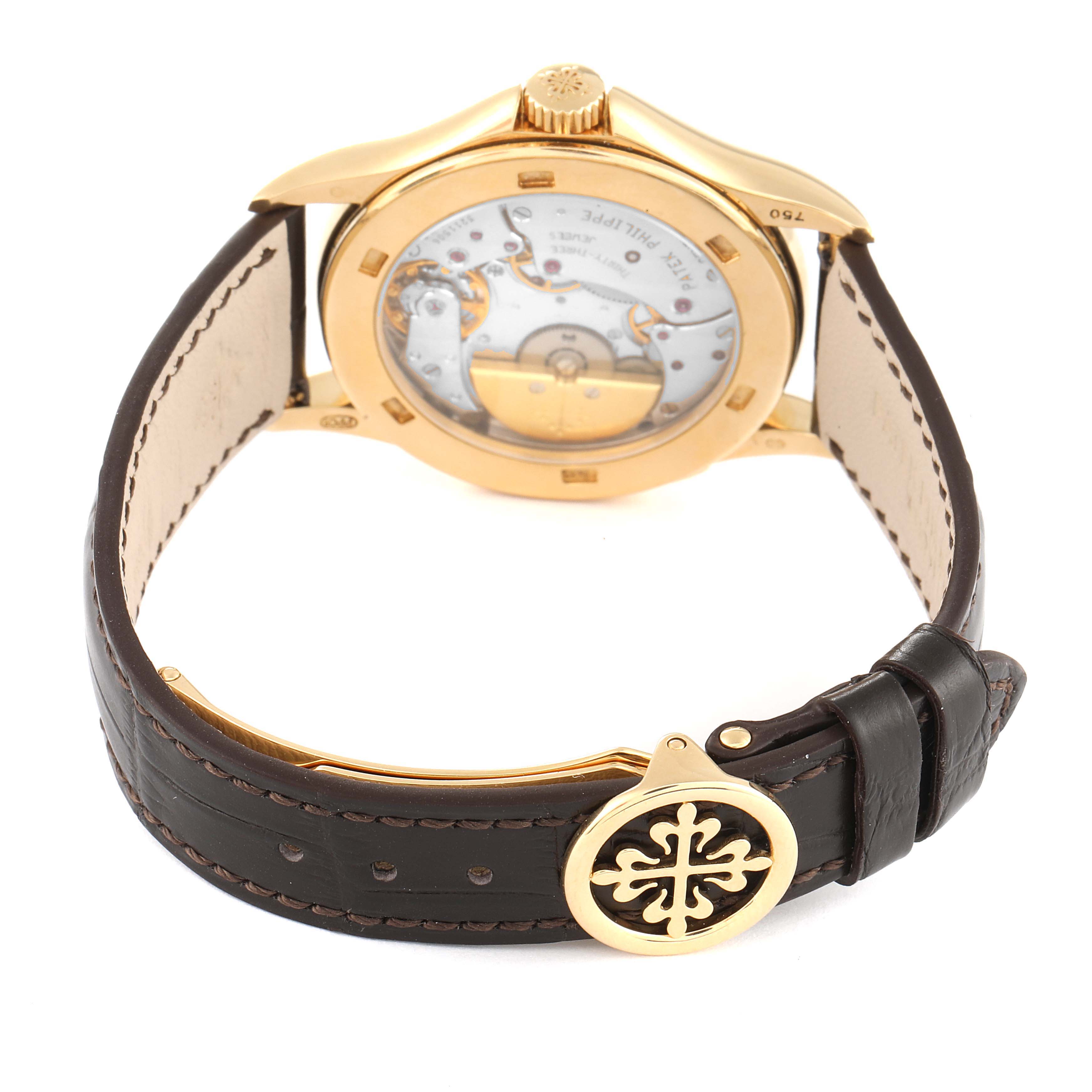 This image shows the back and underside of a Patek Philippe Complications 5110J Men's Yellow Gold Silver Dial 5110J Men's Yellow Gold Silver Dial watch, highlighting its movement and leather strap.