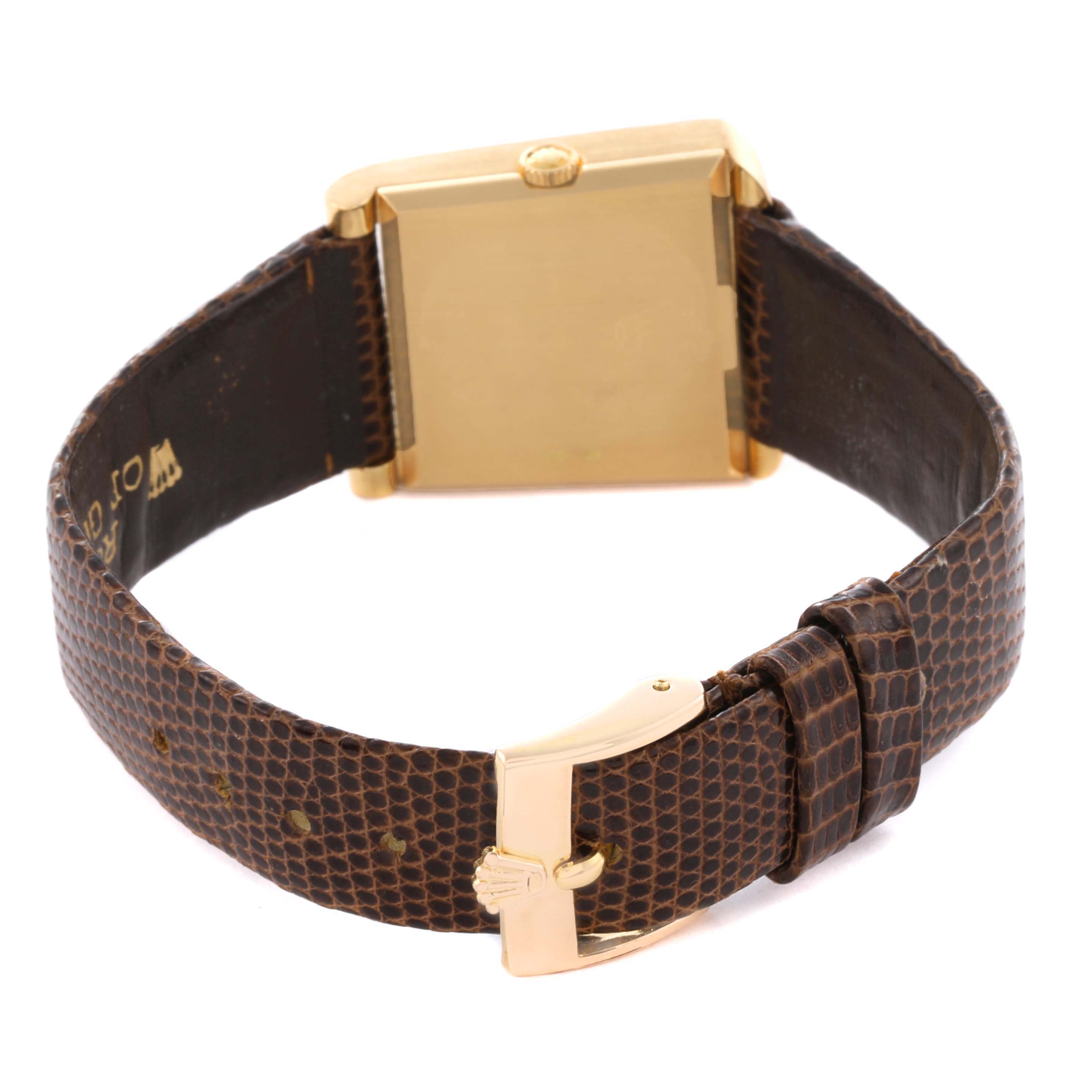 The image shows the backside of a Vintage Collection Rolex watch, featuring a square gold case and brown textured strap with a gold buckle.
