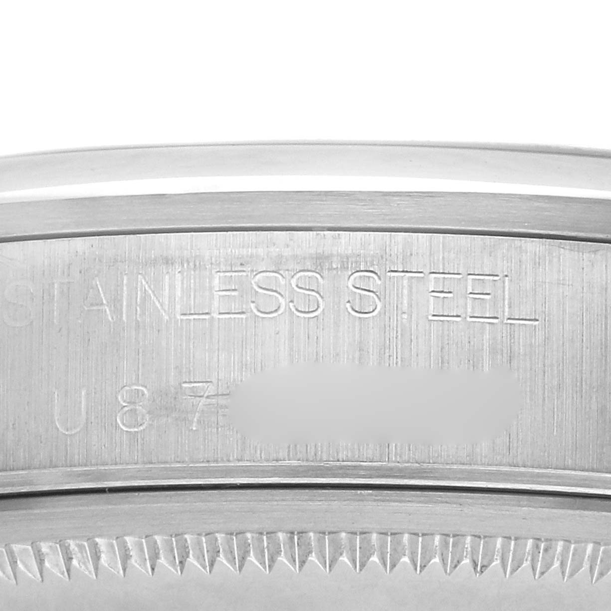 This image shows a close-up of the case edge and serial number of a Rolex Date 15200 Men's Stainless Steel Blue Dial 15200 Men's Stainless Steel Blue Dial model, focusing on the stainless steel inscription.