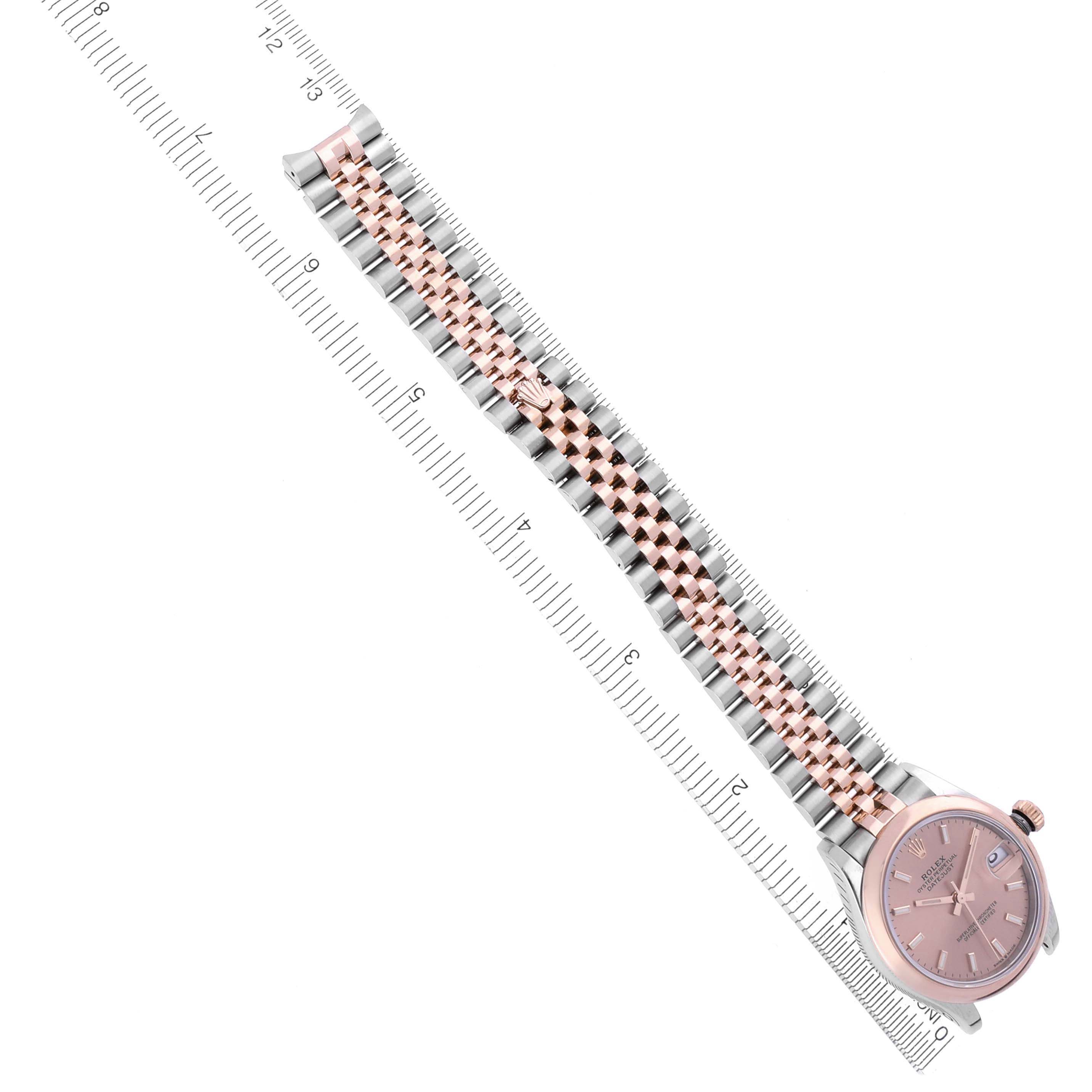 The Rolex Mid-Size 278241 Women's Steel and Gold (two tone) Pink Dial 278241 Women's Steel and Gold (two tone) Pink Dial watch is shown from a top-down angle, displaying its bracelet and face alongside a ruler for scale.