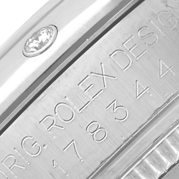 The image shows a close-up of the side of a Rolex Mid-Size 178344 Women's Stainless Steel Mother of Pearl Dial 178344 Women's Stainless Steel Mother of Pearl Dial model, featuring engraved branding and a diamond detail.