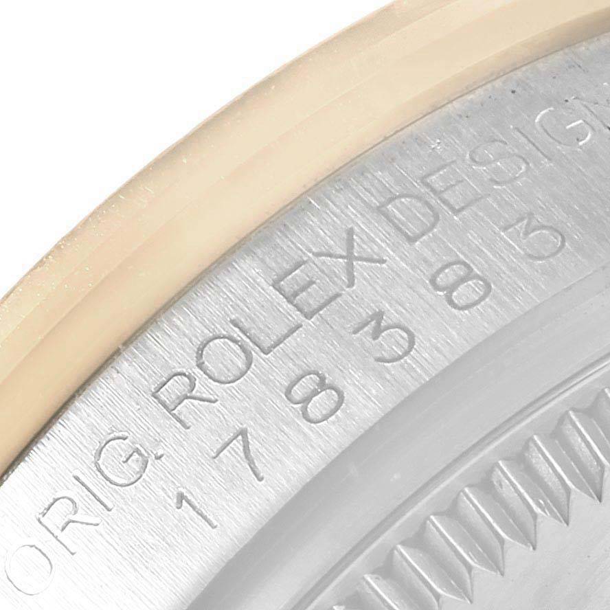 The image shows a close-up of the engraved outer edge of a Rolex Mid-Size watch case with the "ROLEX DESIGN" lettering.