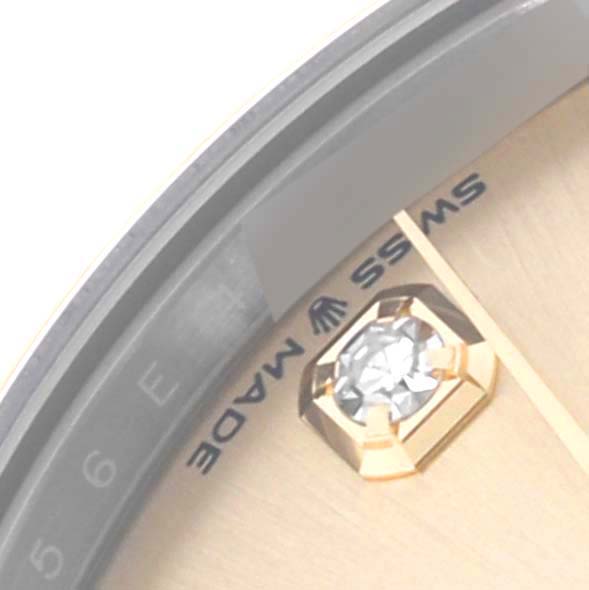 The image shows a close-up of the dial of a Rolex Mid-Size 68032 Women's Steel and Gold (two tone) Champagne Dial 68032 Women's Steel and Gold (two tone) Champagne Dial watch, featuring a diamond marker and part of the "Swiss Made" text.