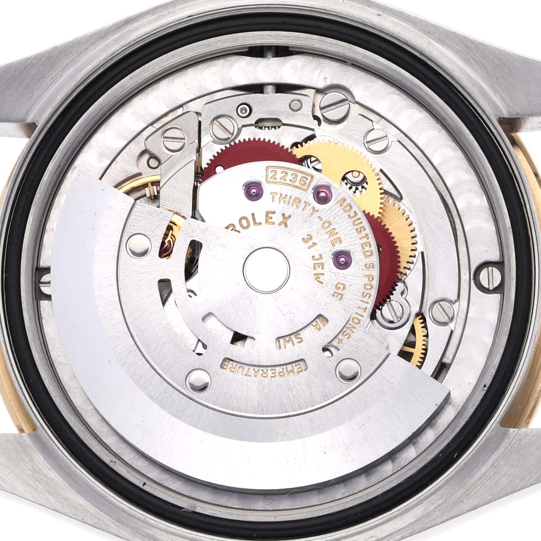 The image shows the inner mechanical movement of a Mid-Size Rolex watch from a back angle, highlighting gears and components.