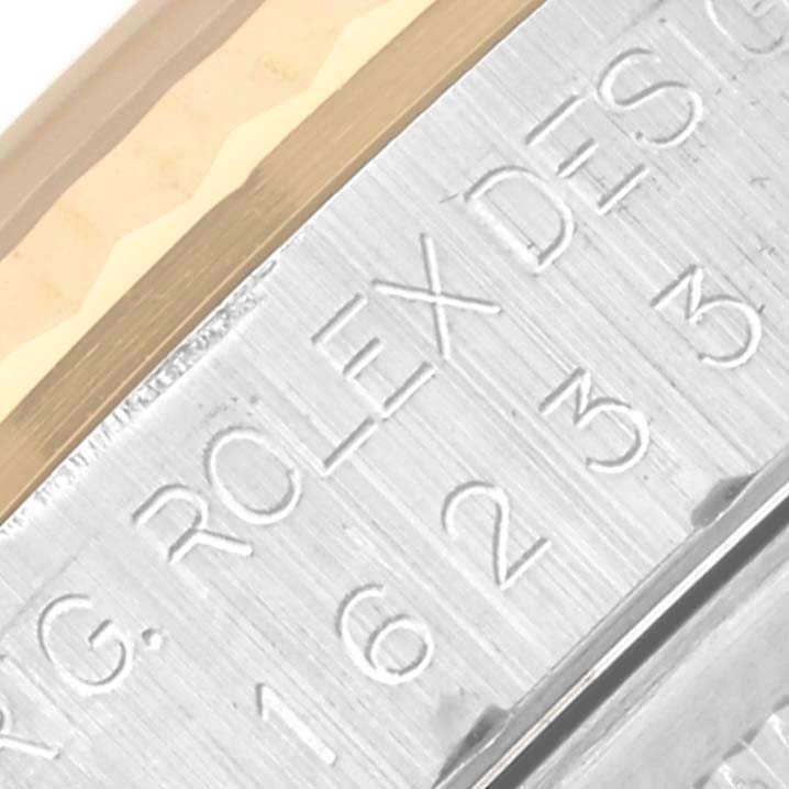 The image shows a close-up of the engraved side of the bezel of a Rolex Datejust 16233 Men's Steel and Gold (two tone) Blue Dial 16233 Men's Steel and Gold (two tone) Blue Dial, highlighting the brand's name.