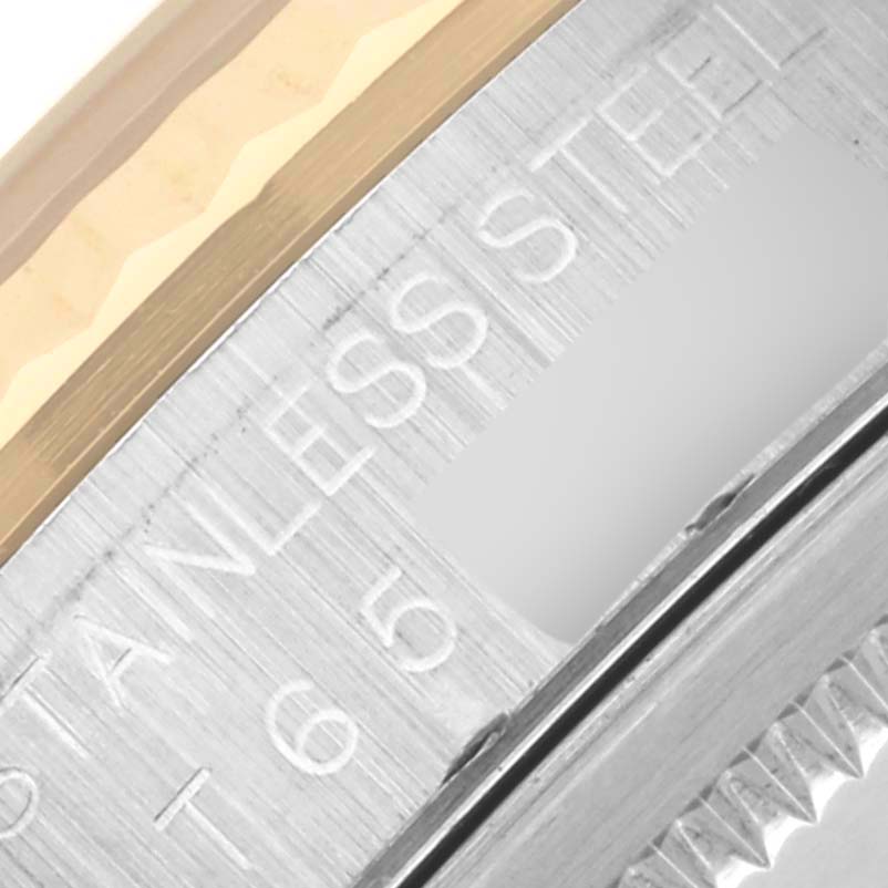 The image shows a close-up of the side of a Rolex Datejust 16233 Men's Steel and Gold (two tone) Blue Dial 16233 Men's Steel and Gold (two tone) Blue Dial, highlighting the engraved "STAINLESS STEEL" text and a portion of the bezel.