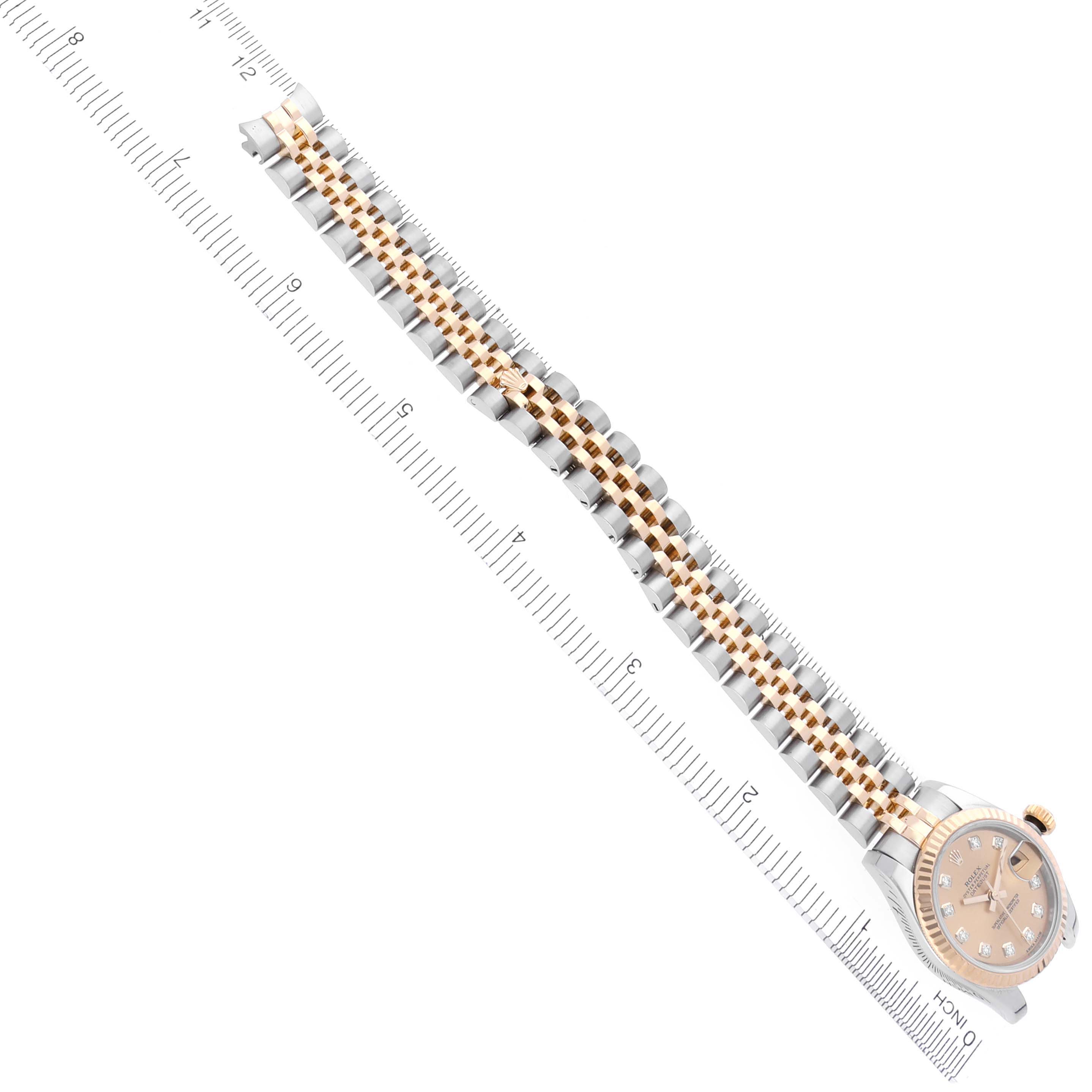The image shows a Rolex Datejust 179173 Women's Steel and Gold (two tone) Champagne Dial 179173 Women's Steel and Gold (two tone) Champagne Dial watch from a top angle, highlighting the dial and two-tone bracelet with a ruler for scale.
