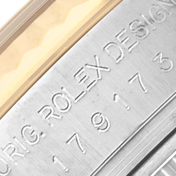 The image shows a close-up of the side of a Rolex Datejust 179173 Women's Steel and Gold (two tone) Champagne Dial 179173 Women's Steel and Gold (two tone) Champagne Dial, focusing on the engraved serial number and part of the bezel.