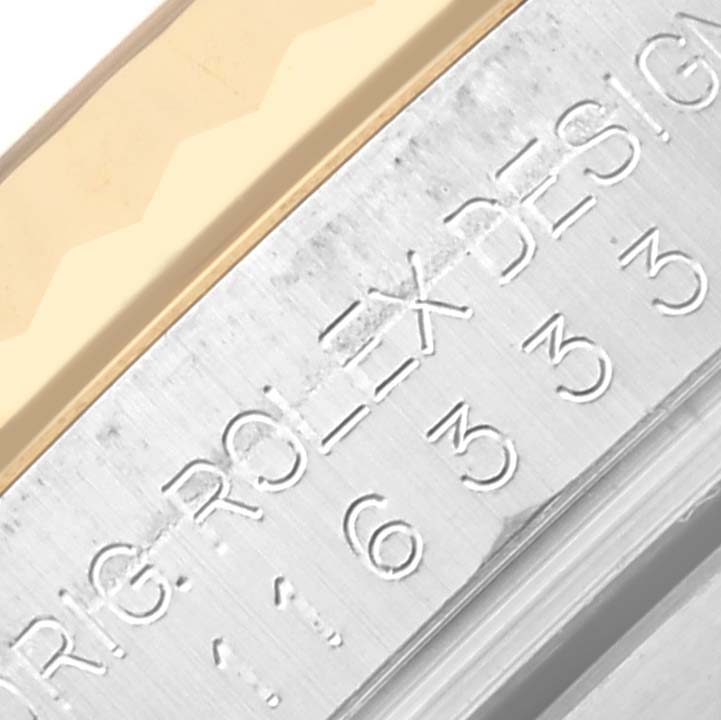This close-up image of the Rolex Datejust 41 116333 Men's Steel and Gold (two tone) Champagne Dial 116333 Men's Steel and Gold (two tone) Champagne Dial shows part of the fluted bezel and engraved inner casing.