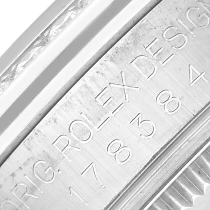The image shows a close-up of the engraved inner bezel of a Rolex Datejust watch.