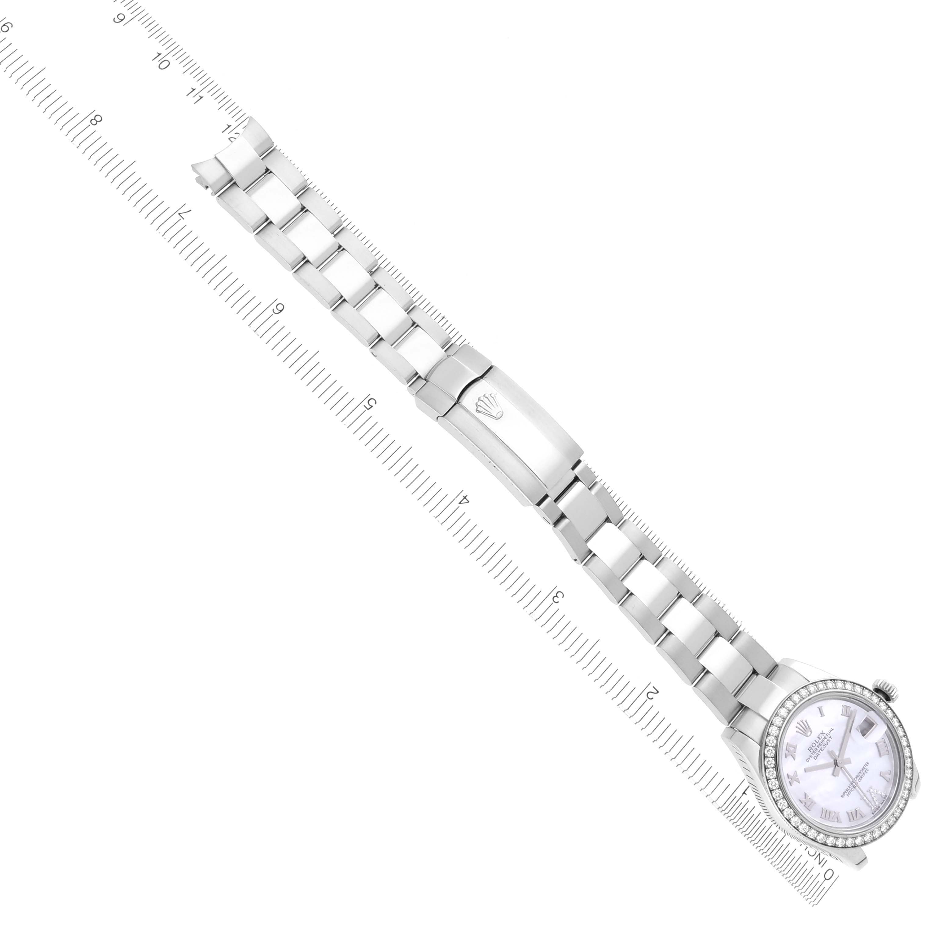 The Rolex Datejust watch is shown from above, displaying the full band, clasp, and face alongside a ruler for scale.