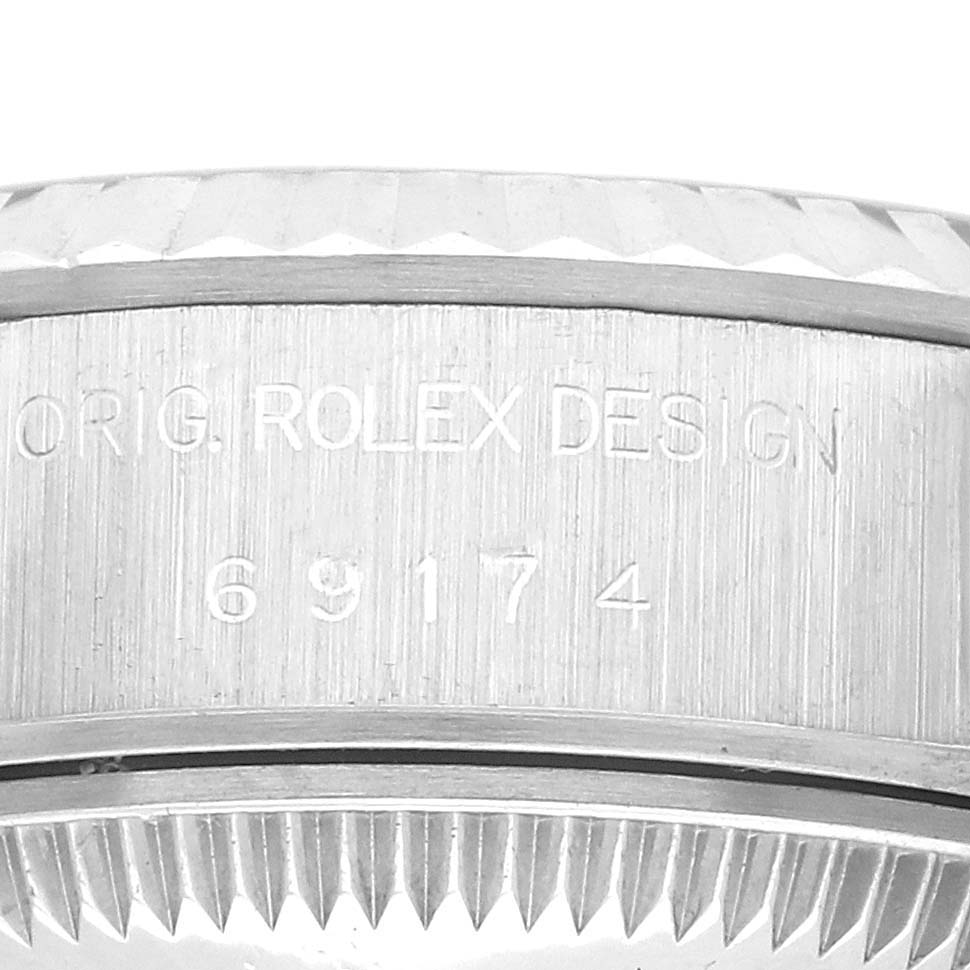 The image shows a close-up side view of the Rolex Datejust 69174 Women's Stainless Steel Silver Dial 69174 Women's Stainless Steel Silver Dial case back, focusing on the model number engraving.