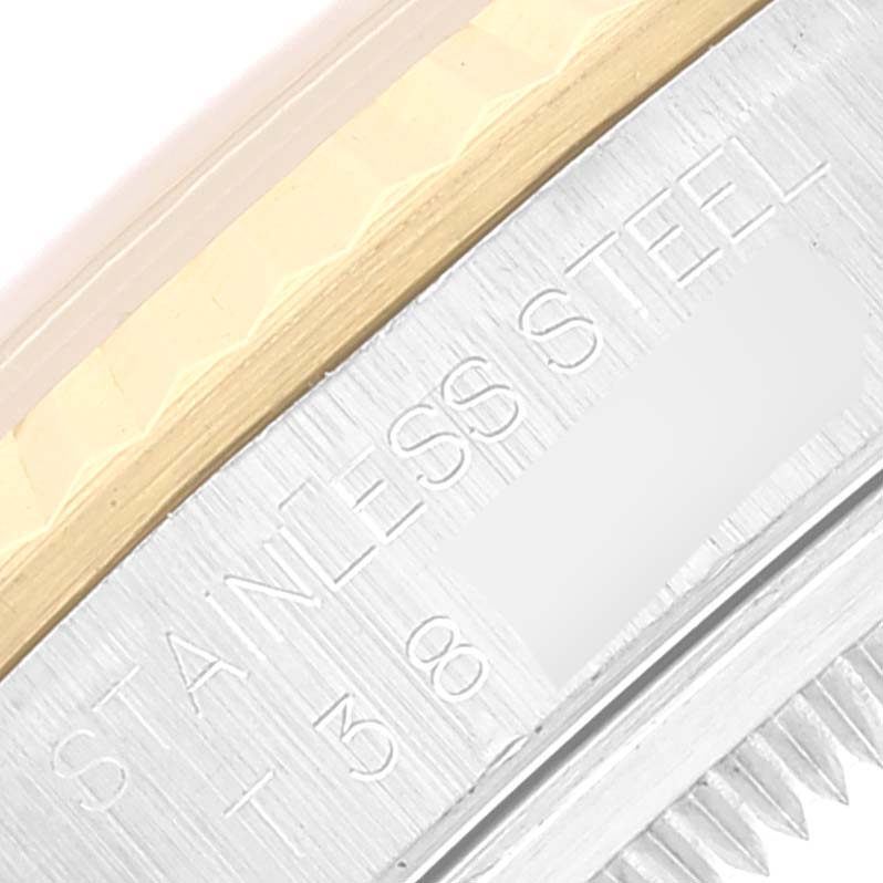 The image shows a close-up of the side of a Rolex Datejust 16233 Men's Steel and Gold (two tone) Beige Dial 16233 Men's Steel and Gold (two tone) Beige Dial, revealing the engraving "STAINLESS STEEL" and part of its fluted bezel.