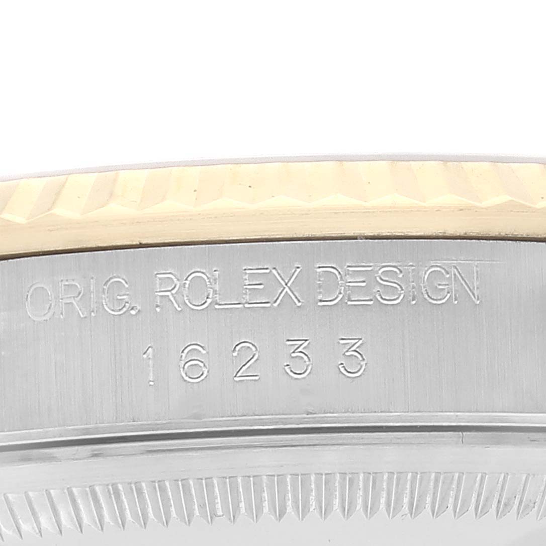 This close-up image shows the engraved side of the bezel for the Rolex Datejust 16233 Men's Steel and Gold (two tone) Silver Dial 16233 Men's Steel and Gold (two tone) Silver Dial model, displaying "Orig. Rolex Design 16233".
