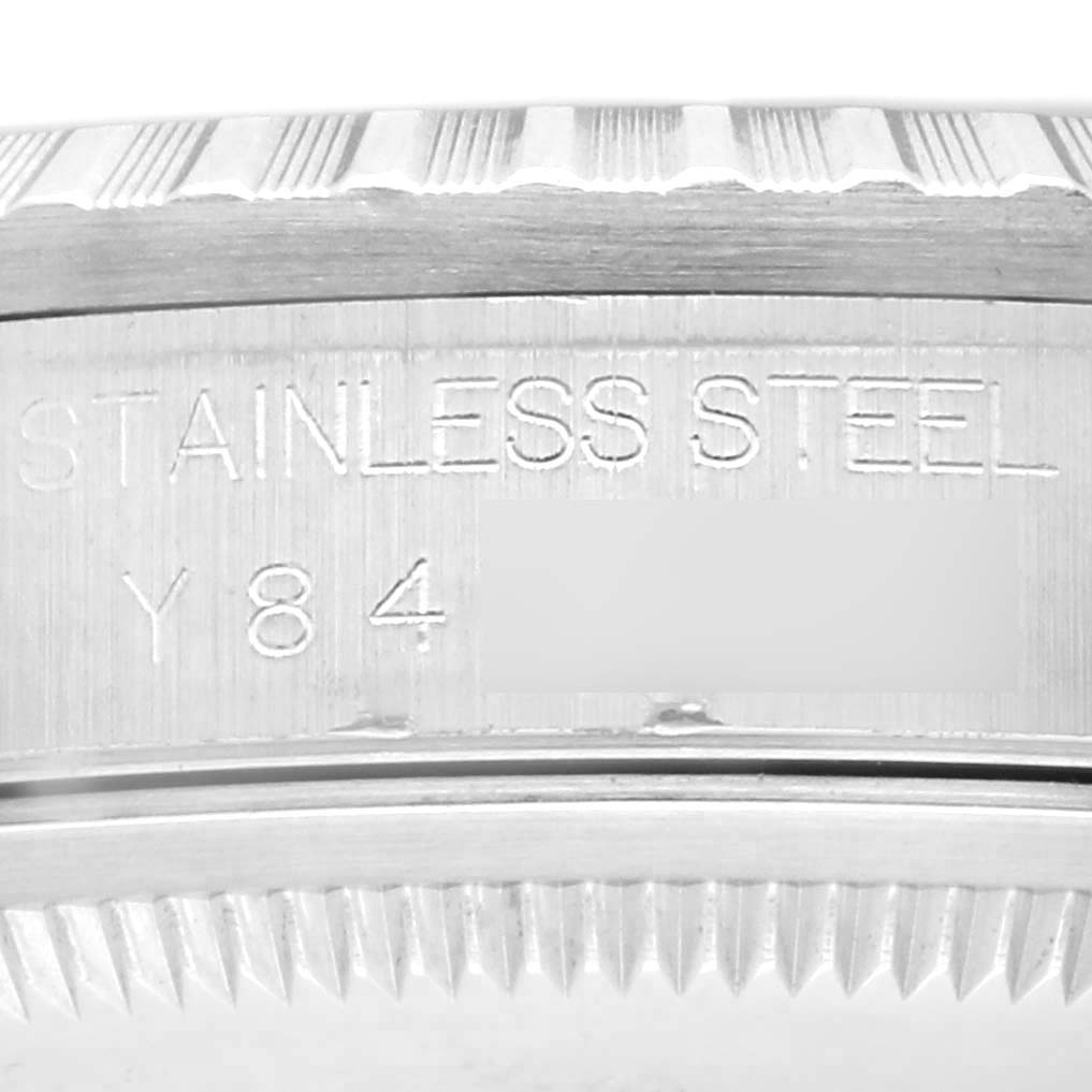 The image shows a close-up of the side view of a Rolex Datejust 16220 Men
s Stainless Steel White Dial 16220 Men
s Stainless Steel White Dial, highlighting the stainless steel markings and part of the bezel.