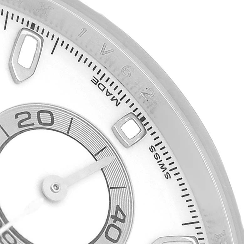 The image shows a close-up of the bezel and part of the dial of a Rolex Daytona 116520 Men's Stainless Steel White Dial, highlighting some markers and numerals.
