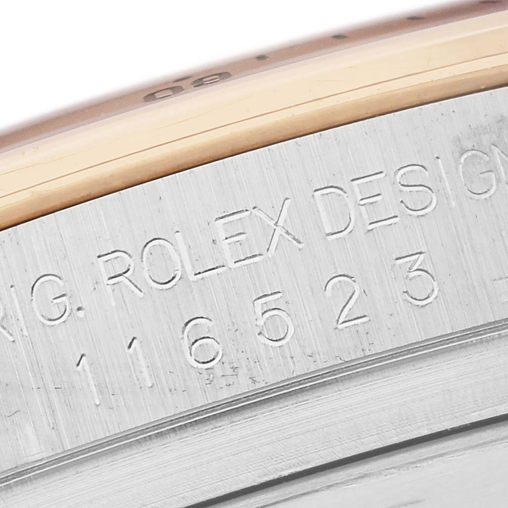 The image shows the side edge of a Rolex Daytona 116523 Men's Steel and Gold (two tone) Mother of Pearl Dial 116523 Men's Steel and Gold (two tone) Mother of Pearl Dial, focusing on the engraved model number and "ROLEX DESIGN" text.