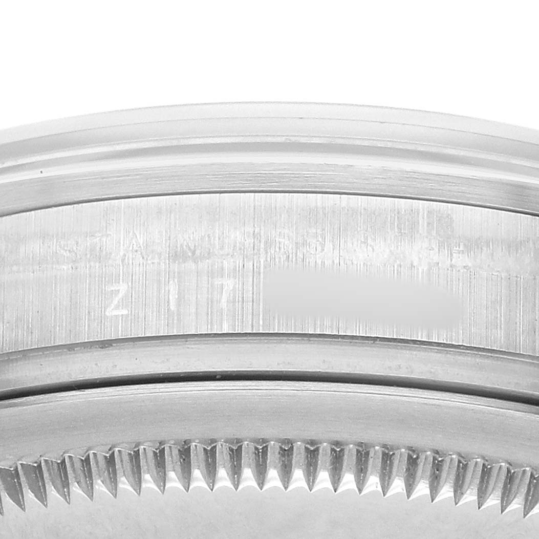 The image shows a close-up of the side of a Rolex Explorer 114270 Men's Stainless Steel Black Dial's case, highlighting the brushed metal texture and part of the bezel.