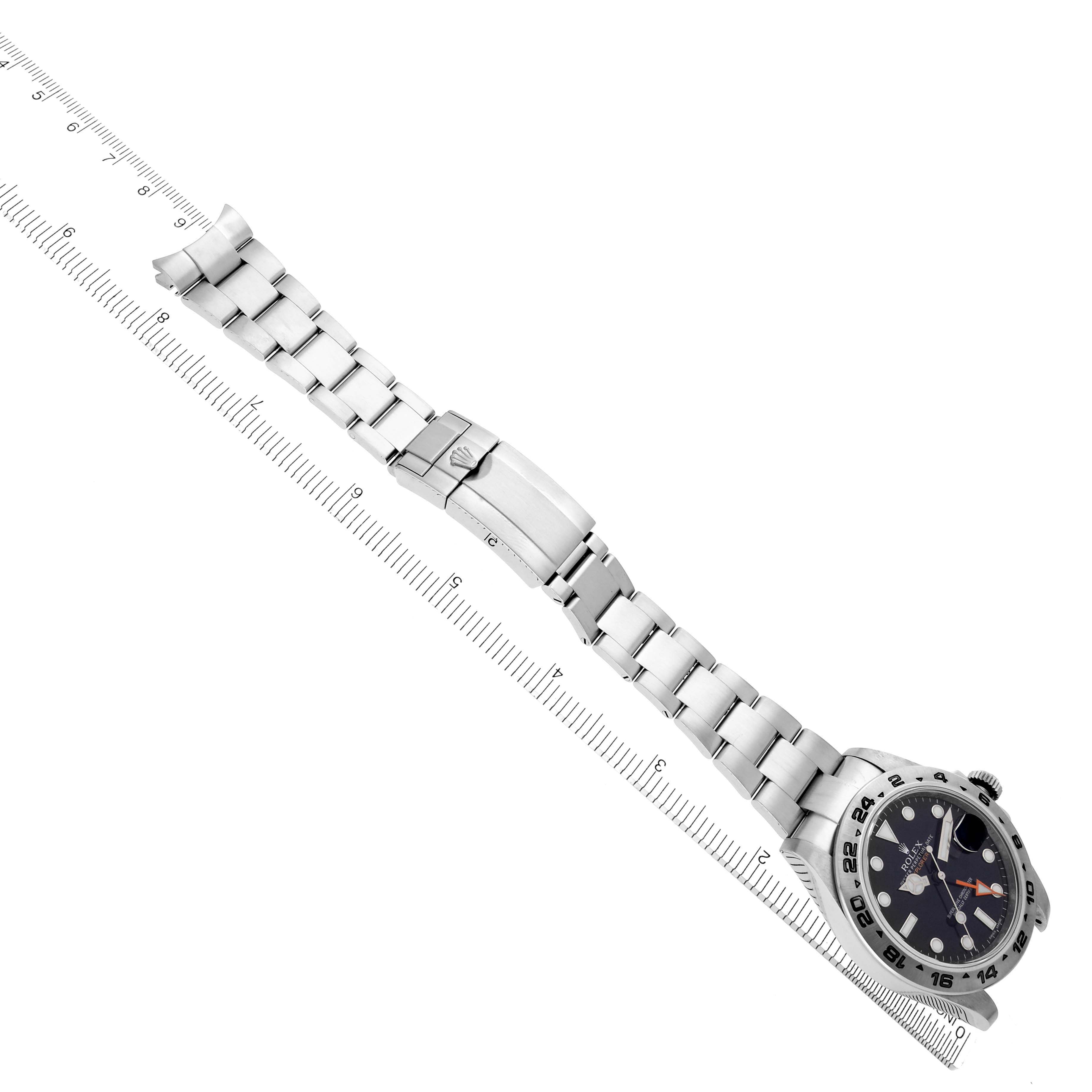 The image shows a top-down view of a Rolex Explorer 216570 Men's Stainless Steel Black Dial 216570 Men's Stainless Steel Black Dial watch and its full stainless steel bracelet, aligned with a ruler.
