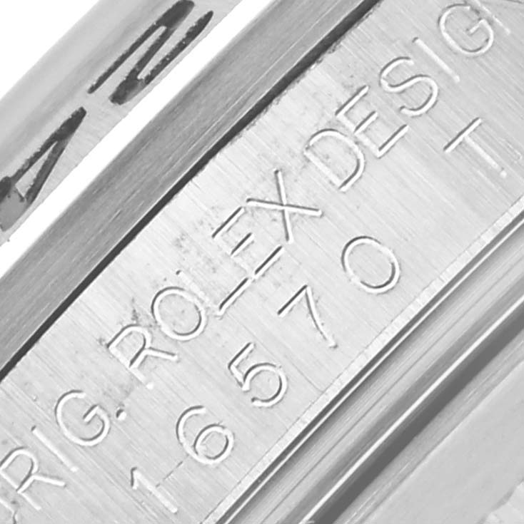 The image shows a close-up of the inner rim on a Rolex Explorer 16570 Men's Stainless Steel White Dial 16570 Men's Stainless Steel White Dial, displaying engravings with the design number.