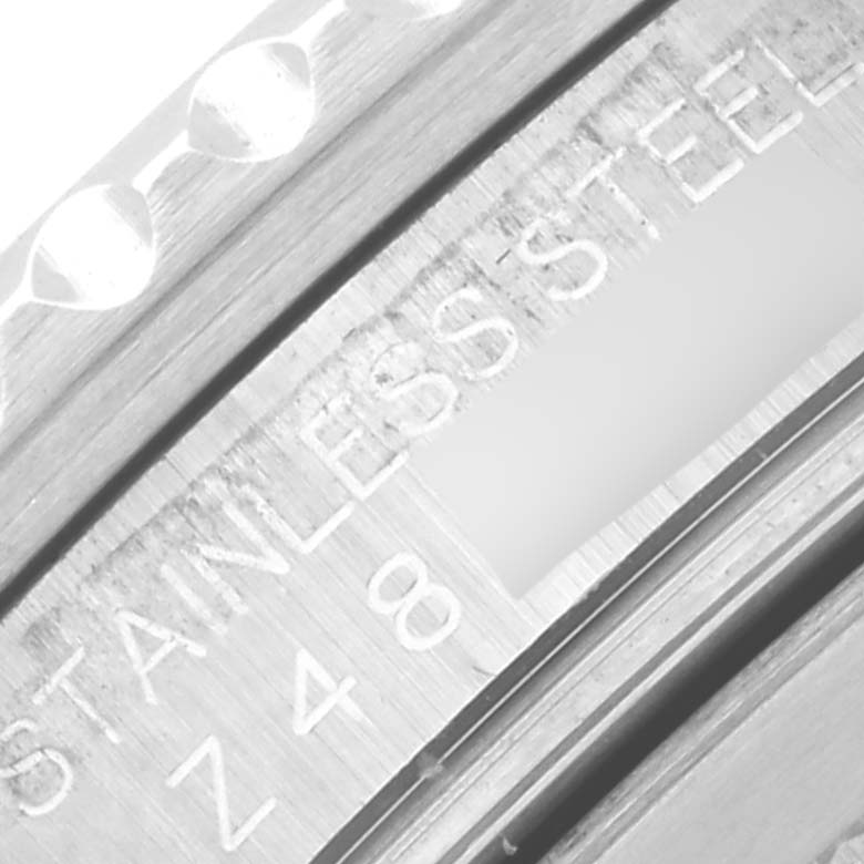 The image shows a close-up of the Rolex GMT-Master 16710 Men's Stainless Steel Black Dial 16710 Men's Stainless Steel Black Dial's bezel, highlighting its stainless steel engraving.