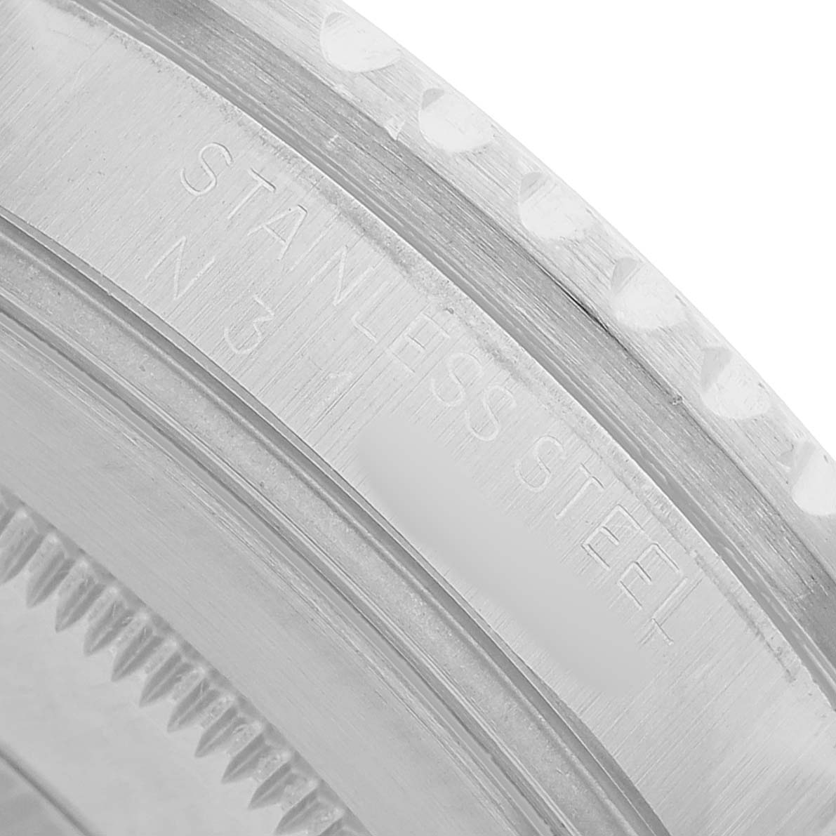 This image shows a close-up of the bezel edge and part of the case back of a Rolex GMT-Master 16710 Men's Stainless Steel Black Dial, highlighting the "STAINLESS STEEL" engraving.