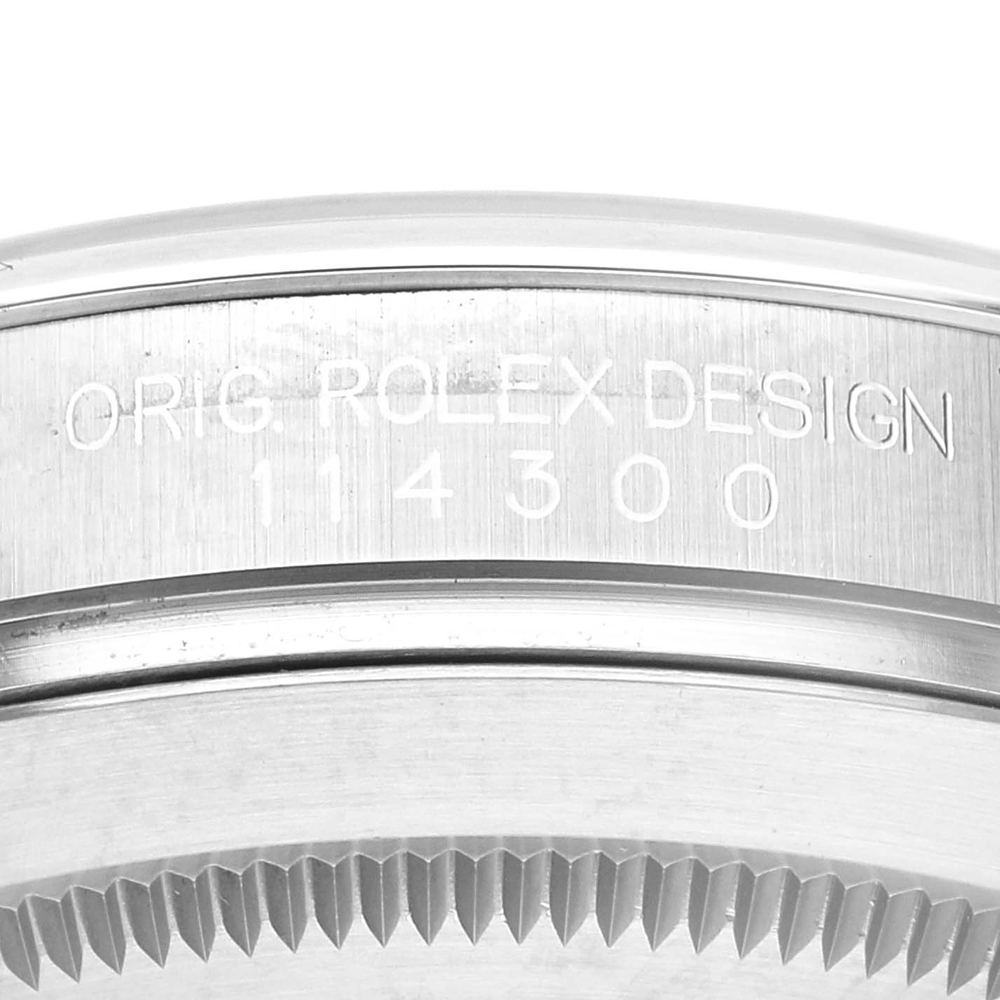 This close-up image shows the side of the casing and bezel of a Rolex Oyster Perpetual 114300 Men's Stainless Steel Grey Dial 114300 Men's Stainless Steel Grey Dial model 114300, highlighting the engraved text.