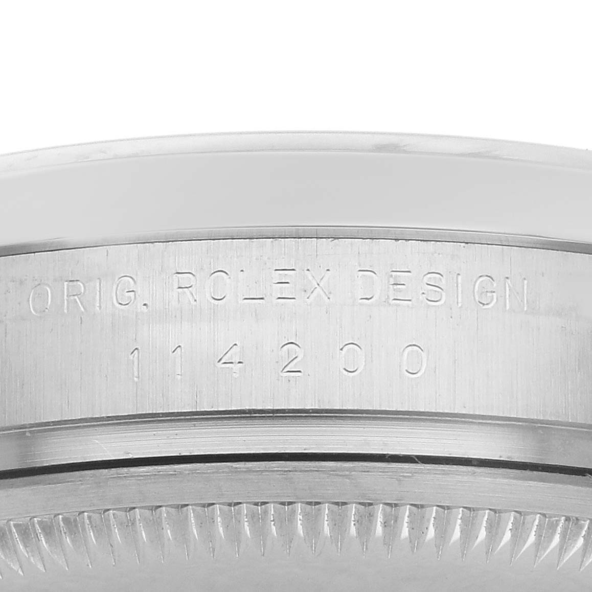 The image shows a close-up side view of the casing edge of a Rolex Oyster Perpetual 114200 Men's Stainless Steel Silver Dial, featuring the model number.