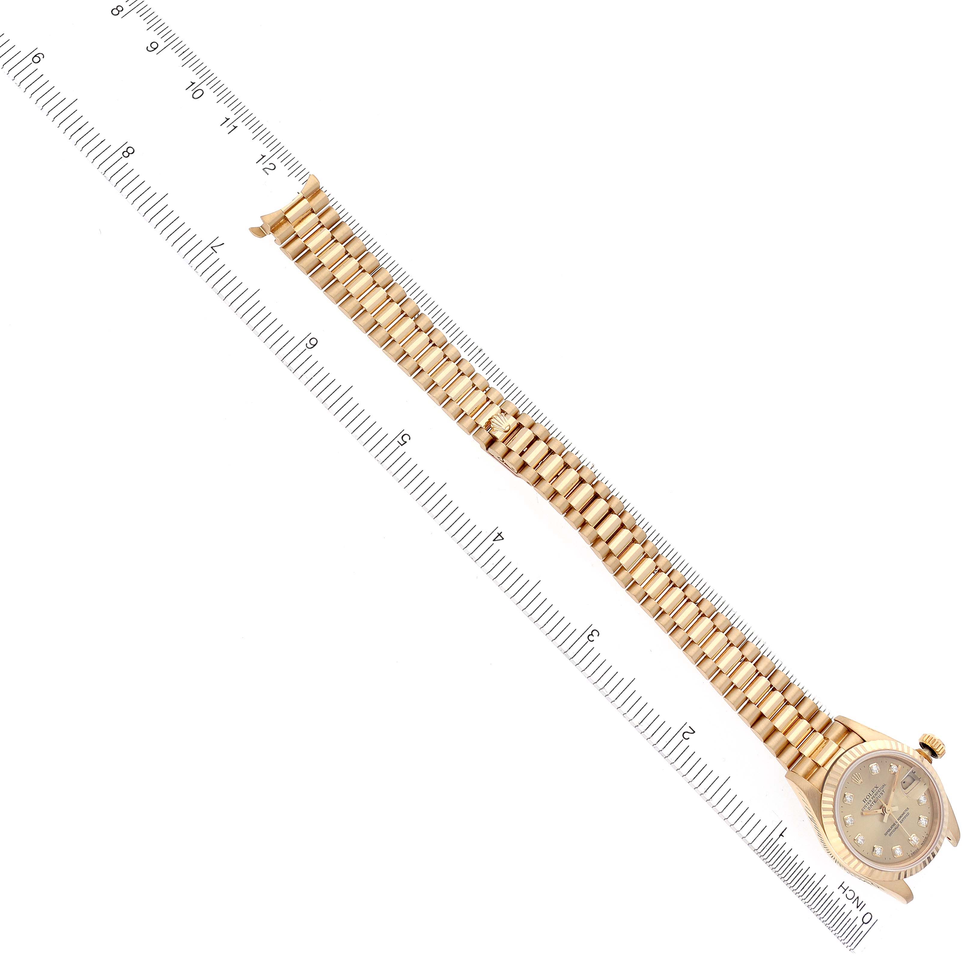 The image shows a Rolex President 69178 Women's Yellow Gold Champagne Dial 69178 Women's Yellow Gold Champagne Dial model watch laid flat alongside a ruler, displaying the bracelet and face.