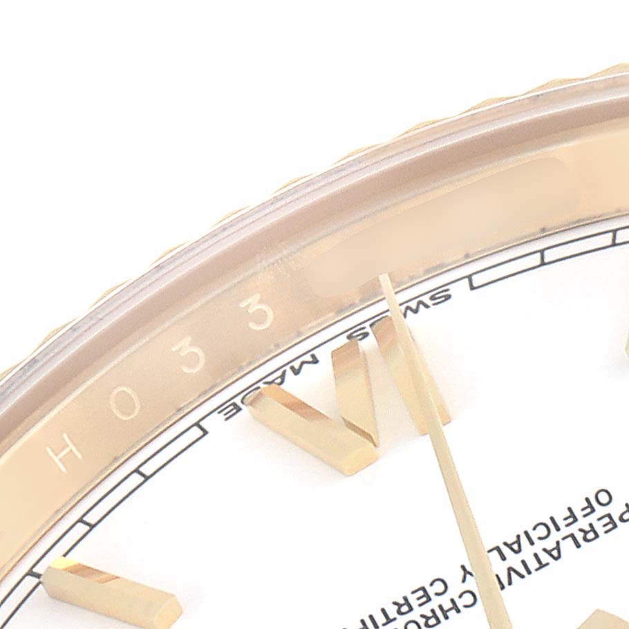 This close-up image shows a part of the bezel, dial, and hour markers of a Rolex President 228238 Men's Yellow Gold White Dial 228238 Men's Yellow Gold White Dial model watch.