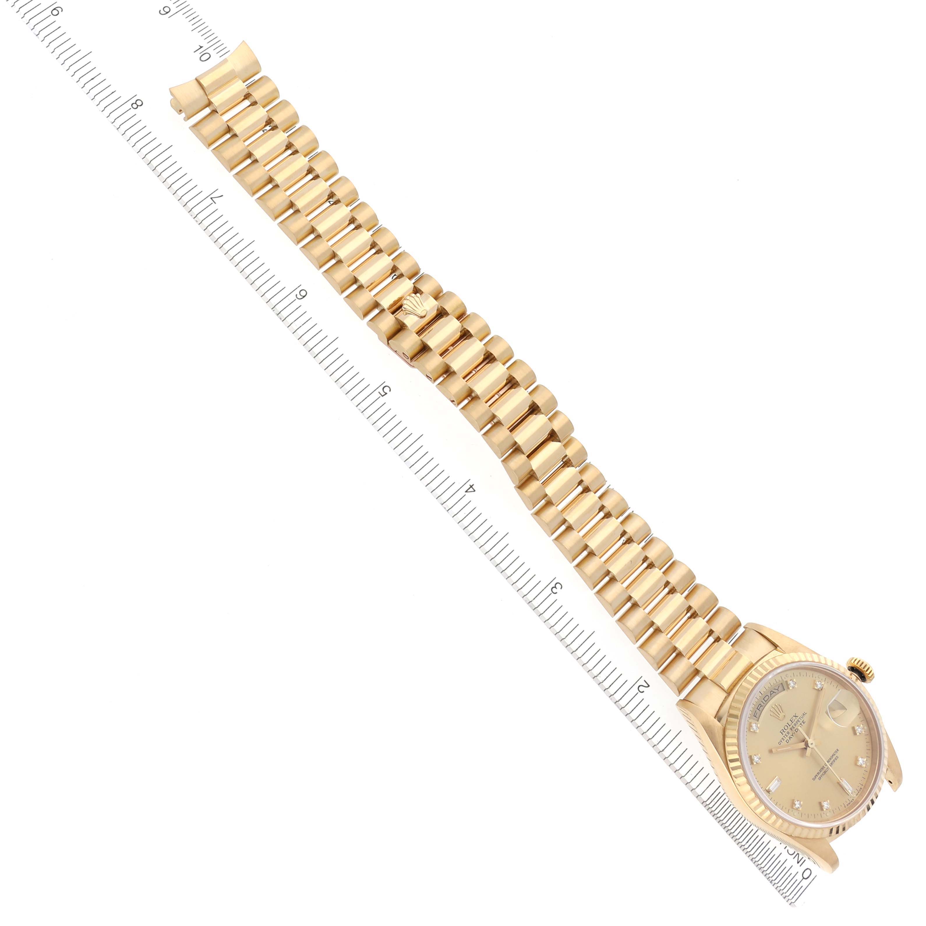 The Rolex President 18238 Men's Yellow Gold Champagne Dial 18238 Men's Yellow Gold Champagne Dial watch is displayed flat, showing the entire bracelet and face, with a ruler along its side for scale.