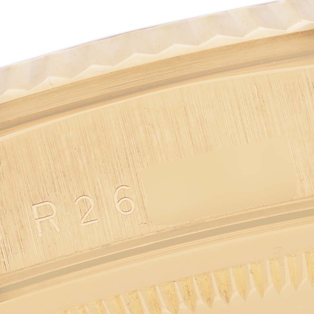 This close-up image of a Rolex President 18238 Men's Yellow Gold Champagne Dial 18238 Men's Yellow Gold Champagne Dial model watch shows part of the gold case with textured edges and engraved details.