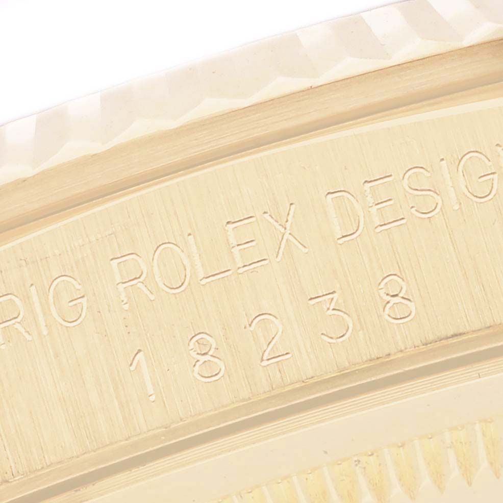 The image shows a close-up of the engraved case side of a Rolex President 18238 Men's Yellow Gold Champagne Dial 18238 Men's Yellow Gold Champagne Dial model, displaying the brand and model number.