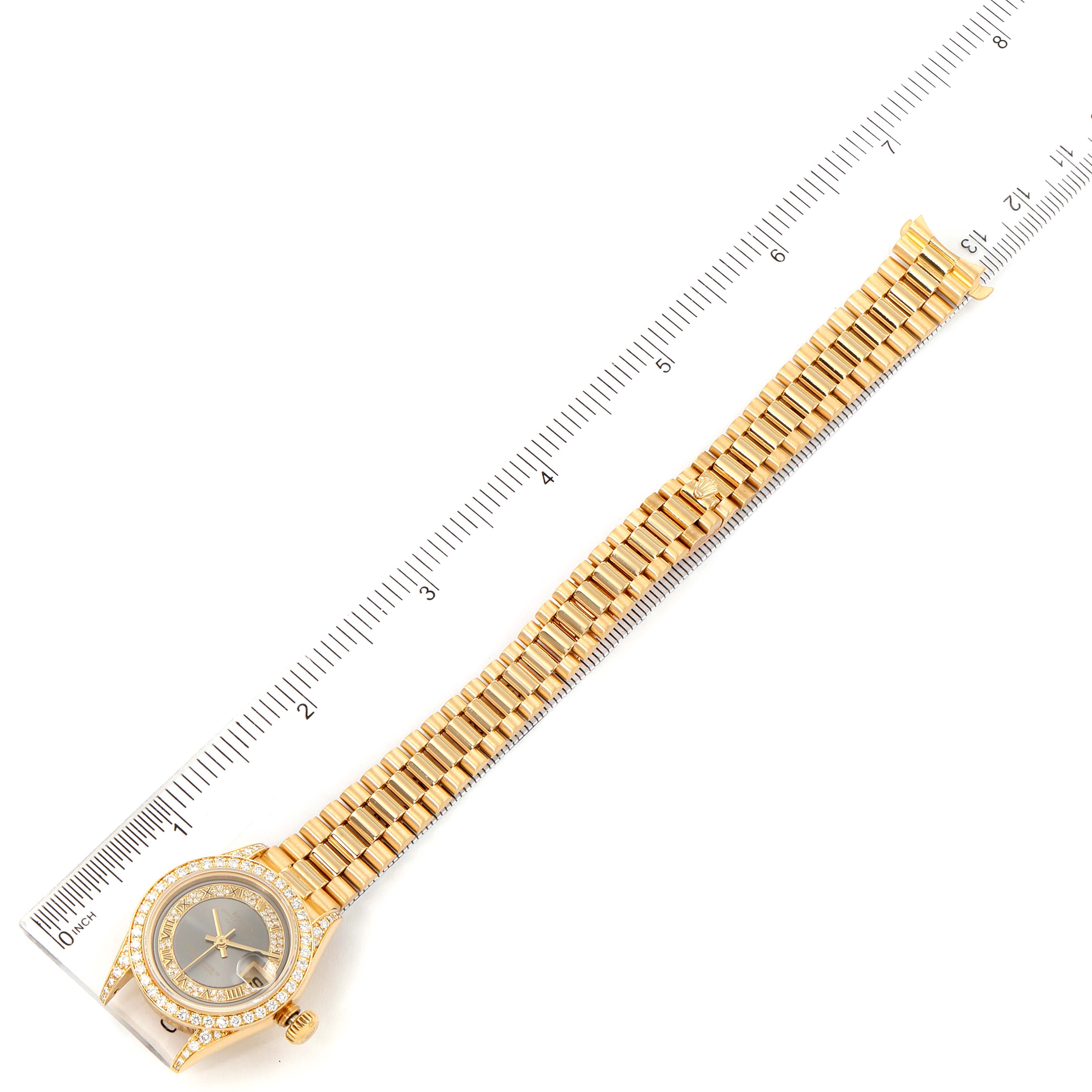 The Rolex President 69158 Women's Yellow Gold Grey Dial 69158 Women's Yellow Gold Grey Dial model watch is shown from a top-down angle with a full view of the band and face, alongside a measuring ruler.