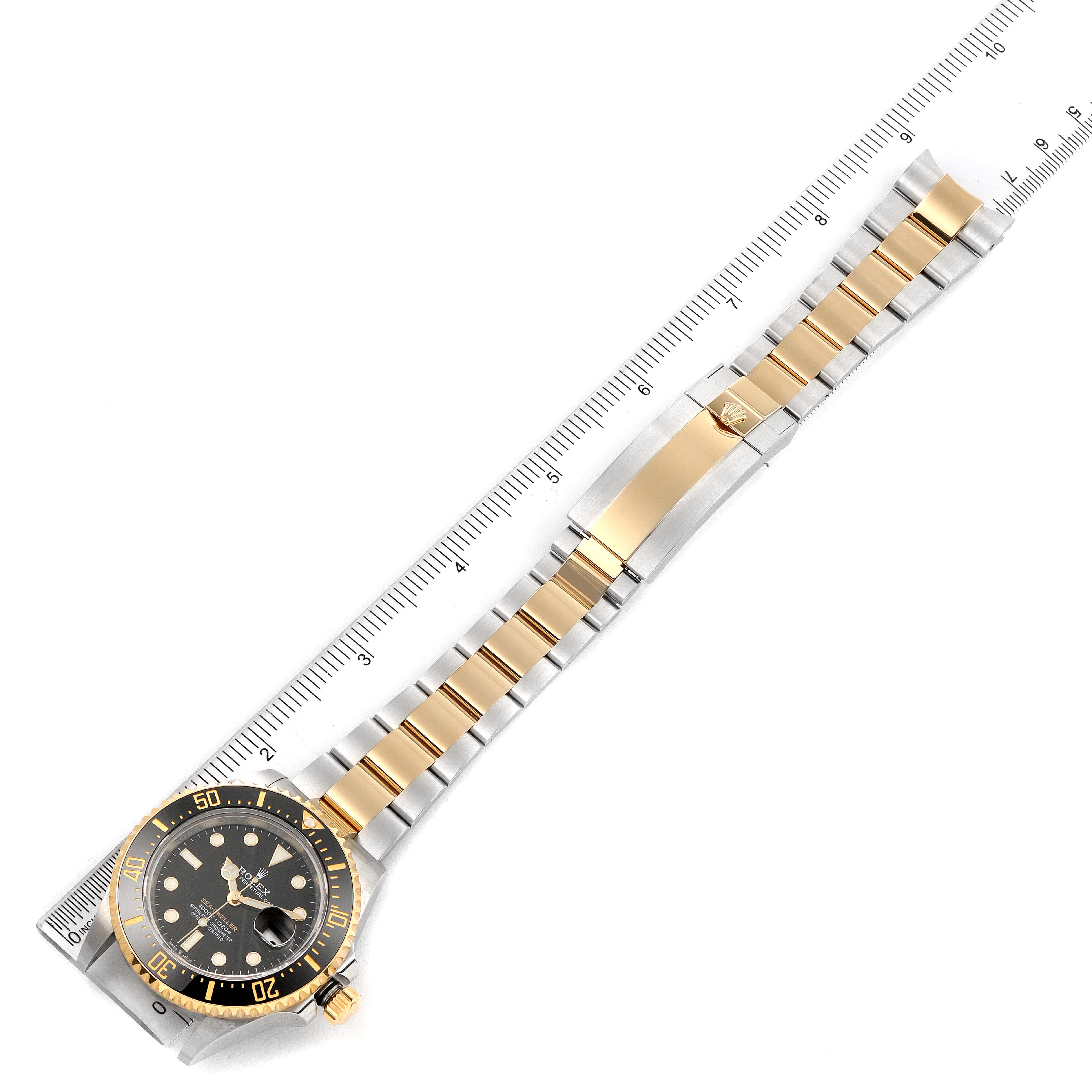 The Rolex Sea-Dweller 126603 Men's Steel and Gold (two tone) Black Dial 126603 Men's Steel and Gold (two tone) Black Dial watch is shown from a top-down angle, displaying the full band and face next to a ruler.