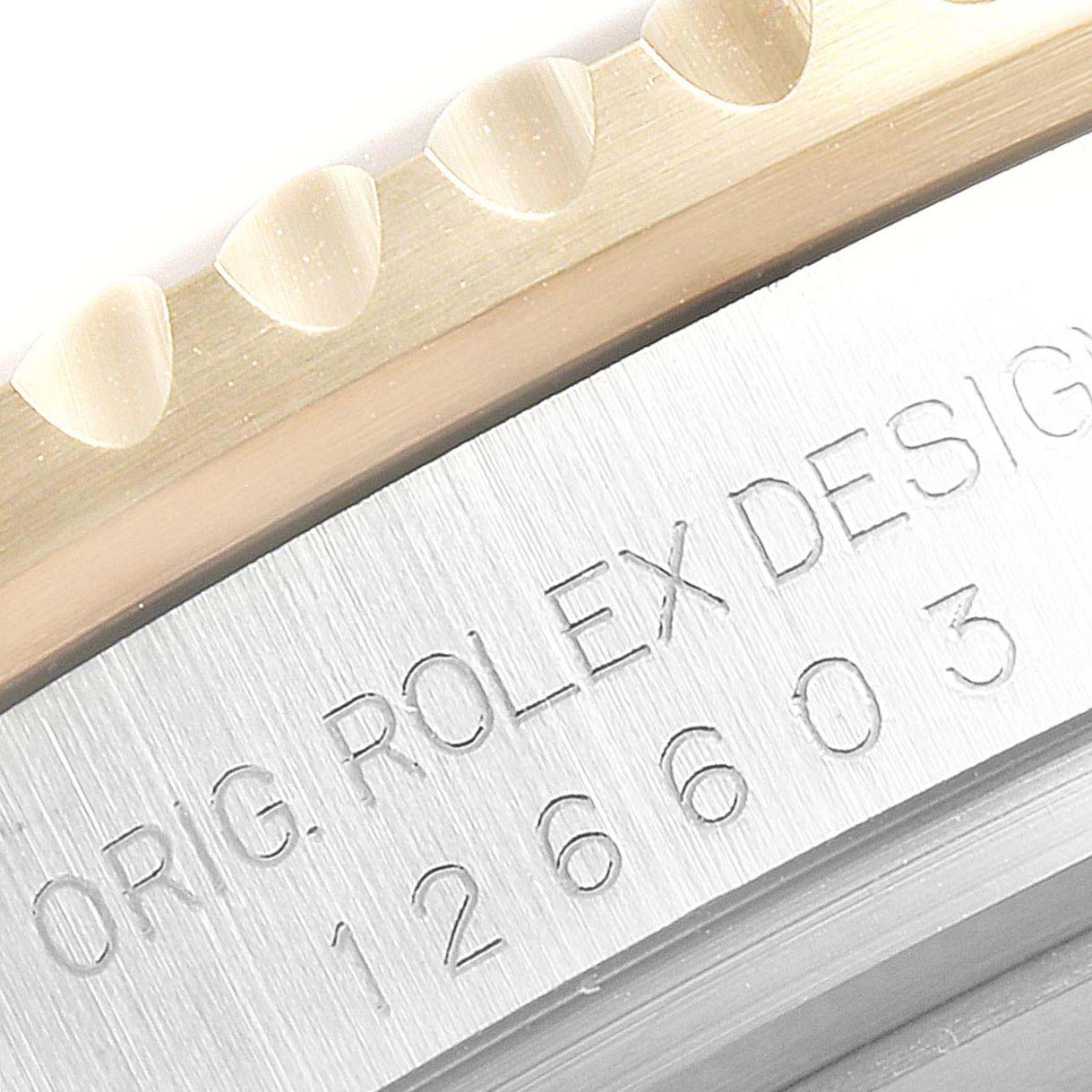 The image shows a close-up of the etched model number and edge of the bezel of a Rolex Sea-Dweller 126603 Men's Steel and Gold (two tone) Black Dial 126603 Men's Steel and Gold (two tone) Black Dial watch.