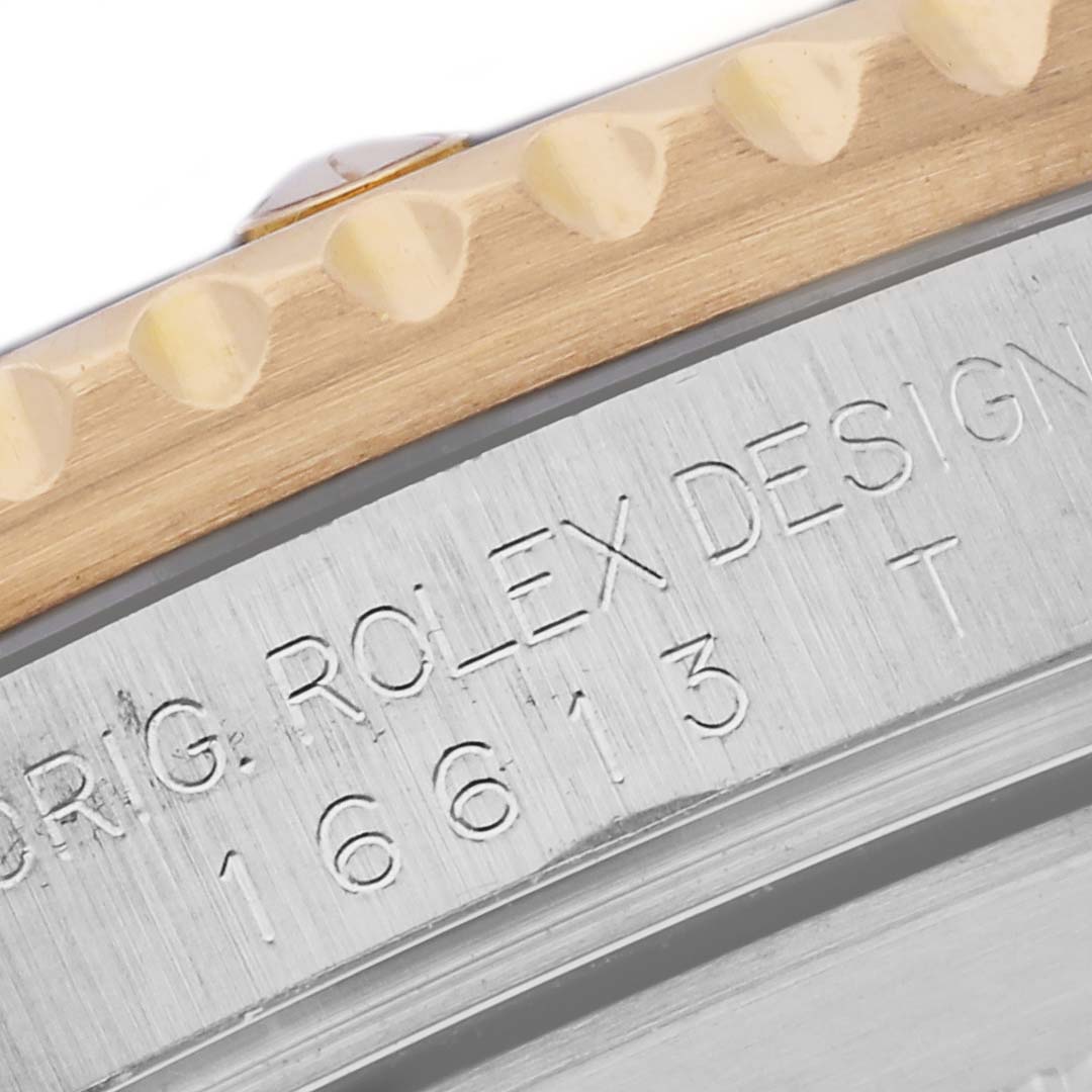 The image shows a close-up angle of the Rolex Submariner 16613 Men's Steel and Gold (two tone) Blue Dial 16613 Men's Steel and Gold (two tone) Blue Dial's bezel and case side, with engraved text visible.