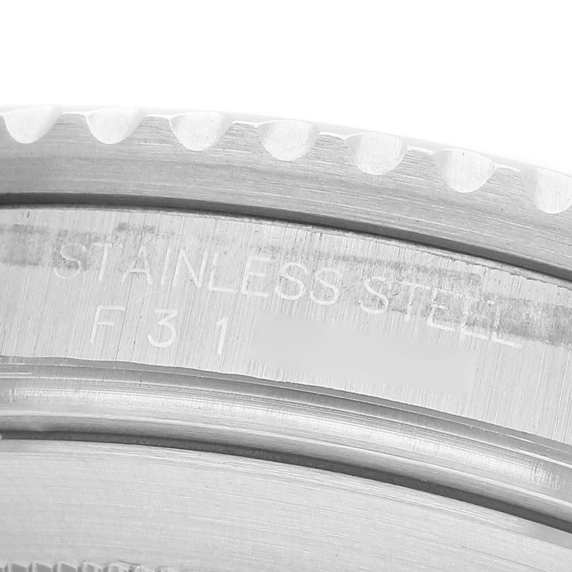 The image shows a close-up of a Rolex Submariner 16610 Men's Stainless Steel Black Dial's stainless steel bezel and engravings.